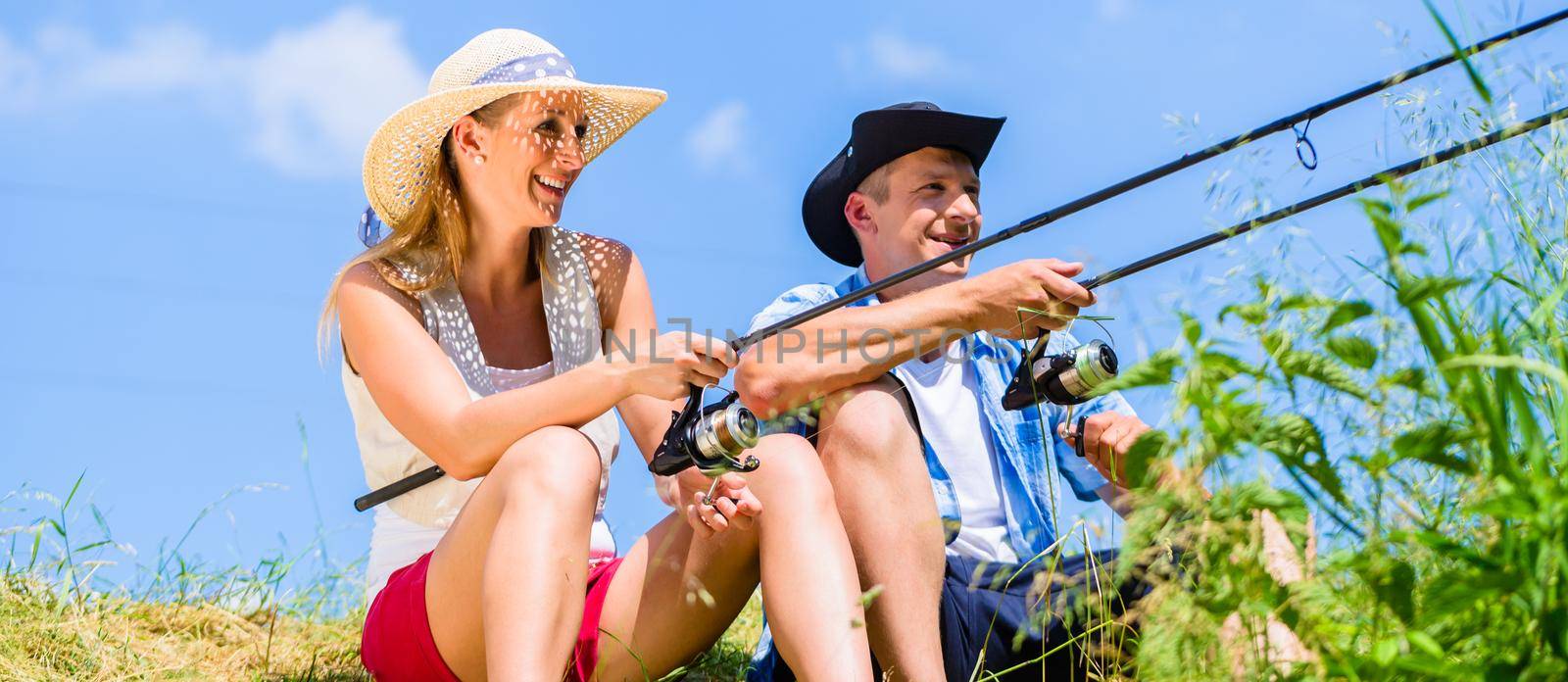 Couple, woman and man, with fishing rods sport angling by Kzenon