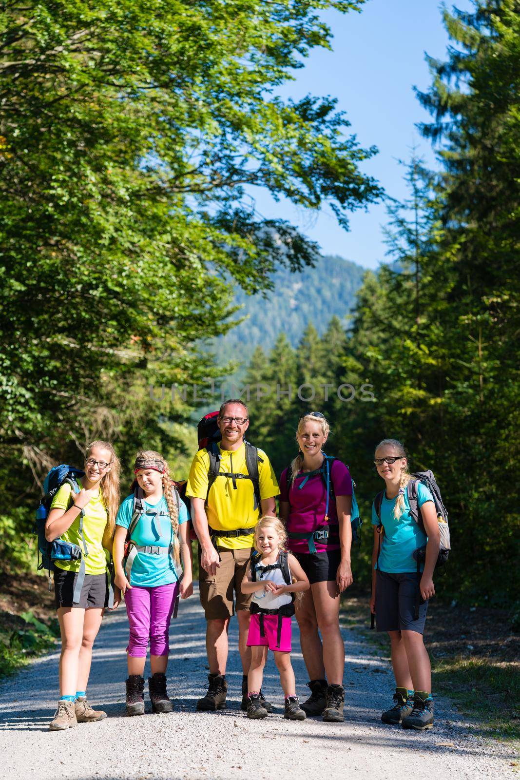 Family with four kids hiking in the mountains by Kzenon
