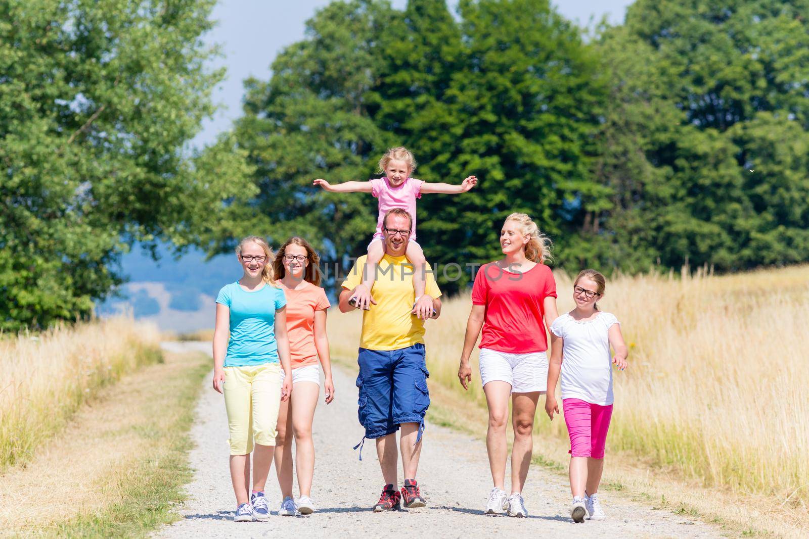 Family having walk on path in summer by Kzenon