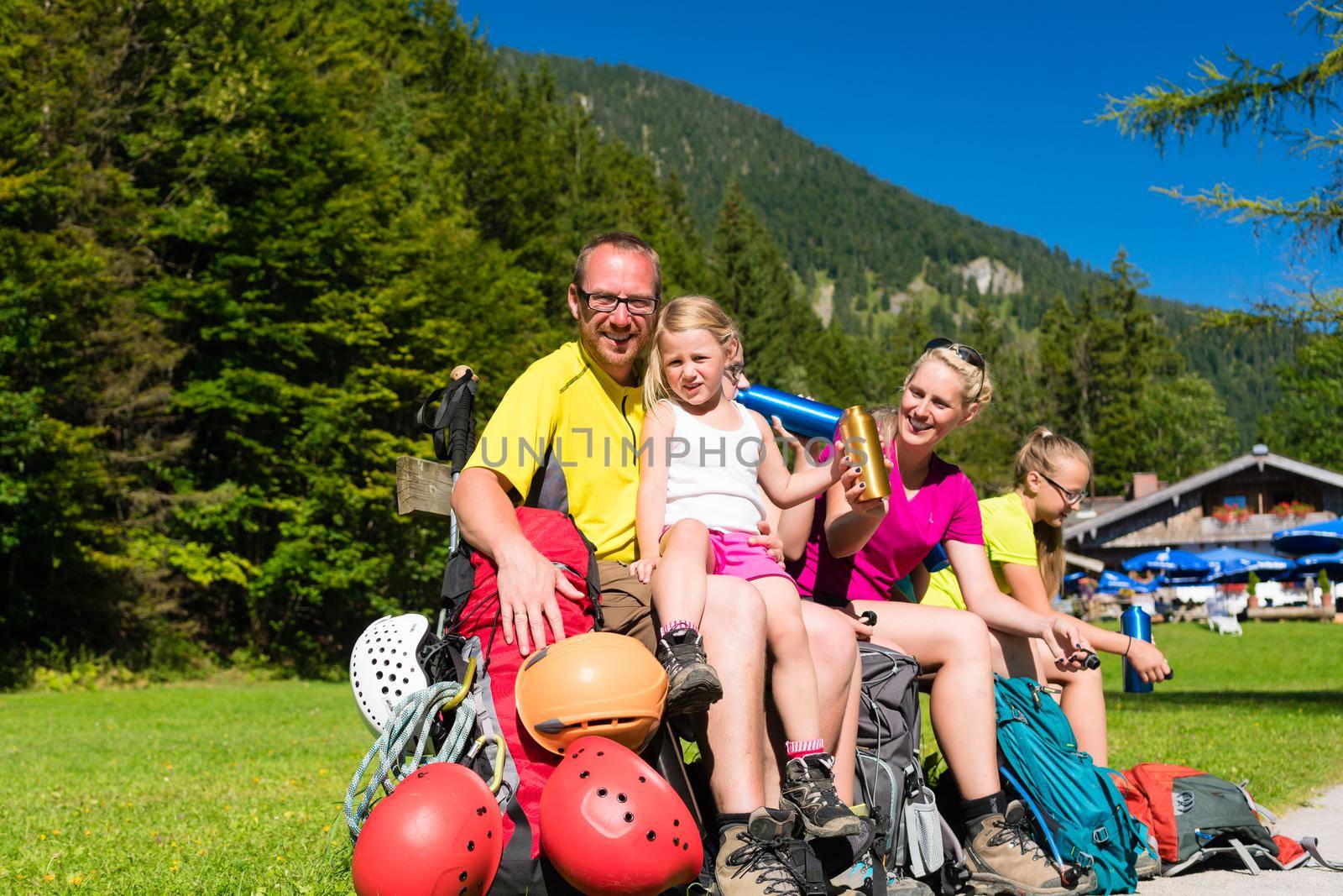 Happy family having break from hiking in the mountains