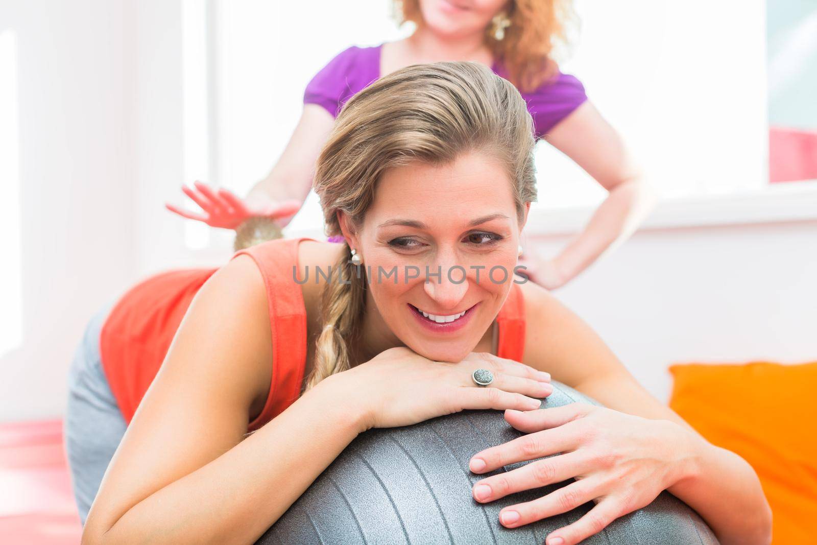 Pregnant young women getting backrub with spiky massage ball by Kzenon