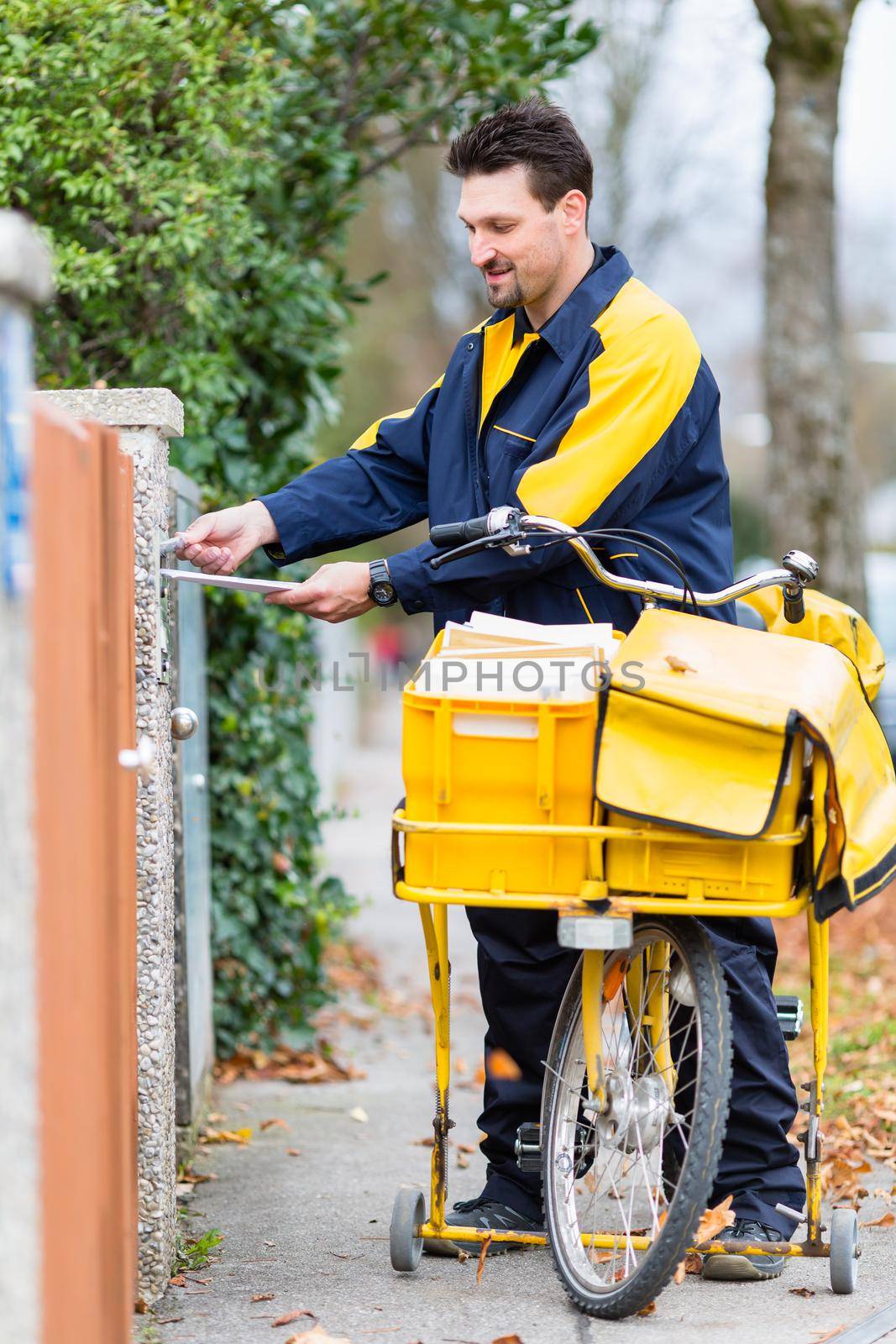 Postman delivering letters to mailbox of recipient