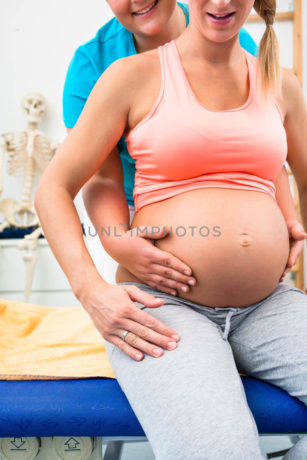 Pregnant woman with physical therapist sitting on couch