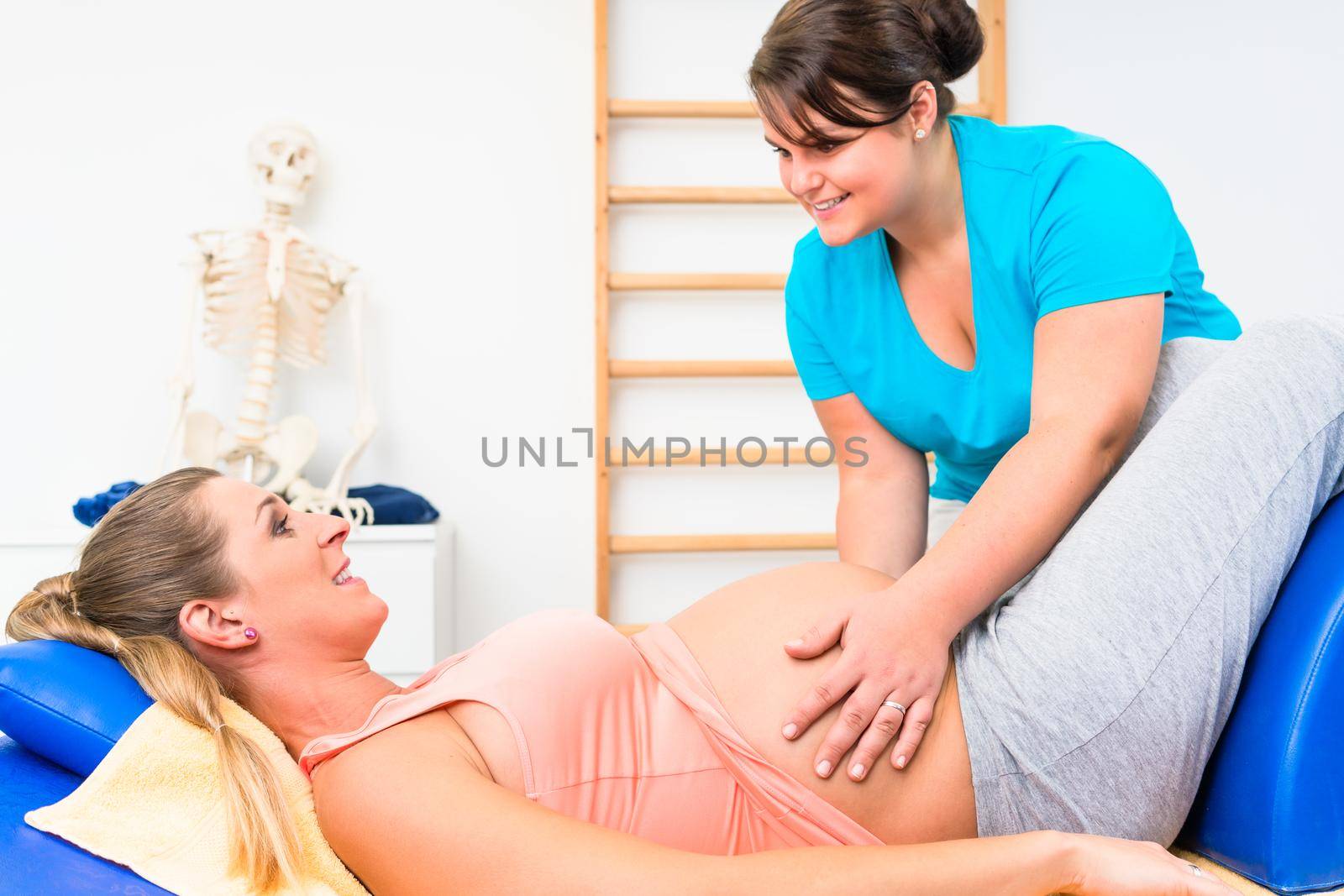 Pregnant woman at physical therapy on couch by Kzenon