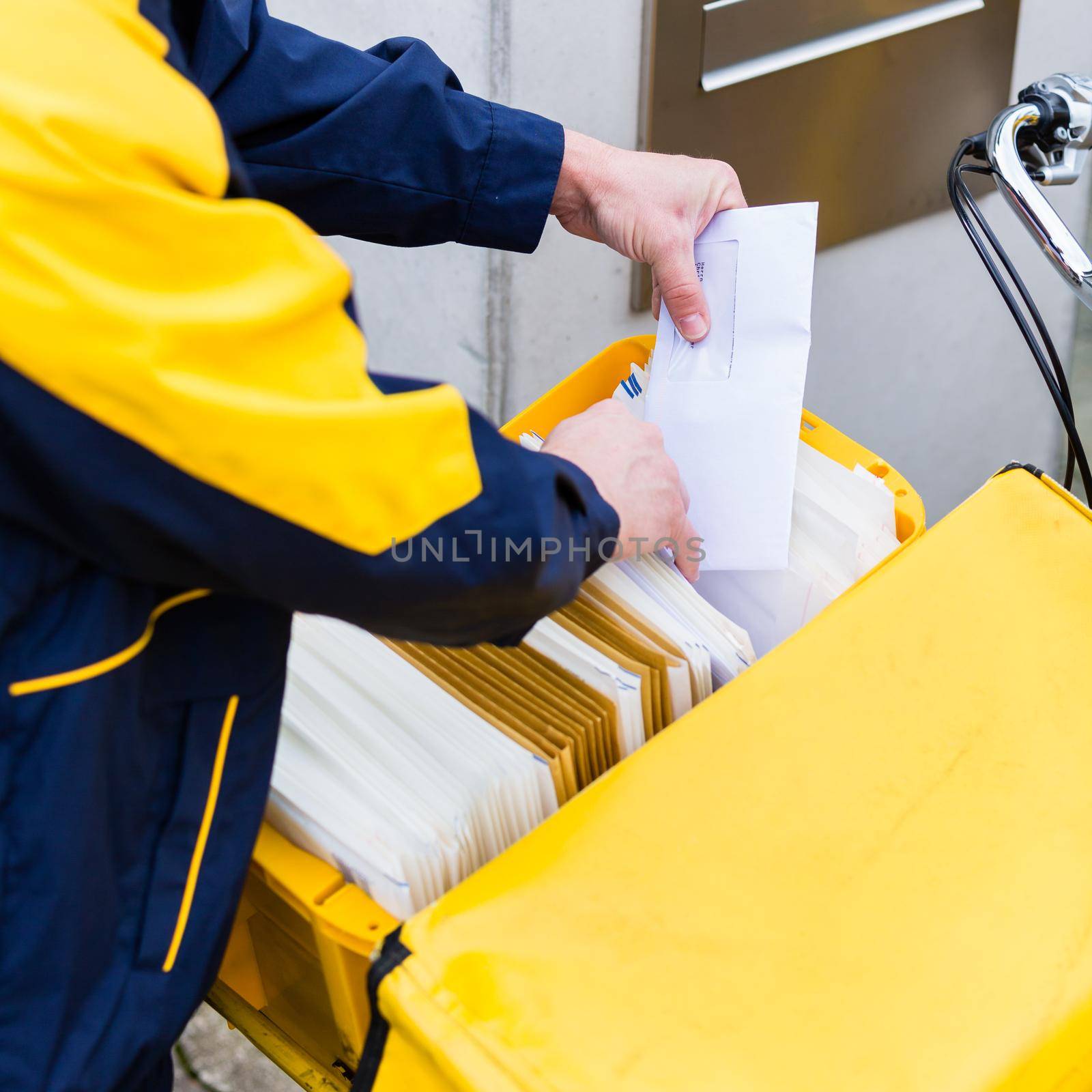 Postman delivering letters to mailbox of recipient