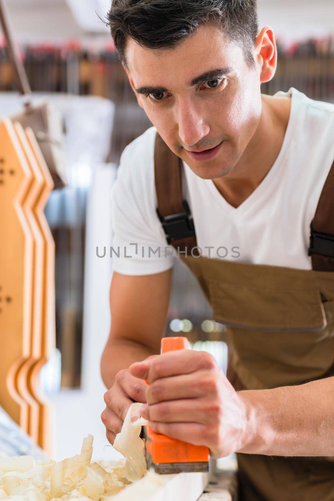 Carpenter with wood planer working on piece