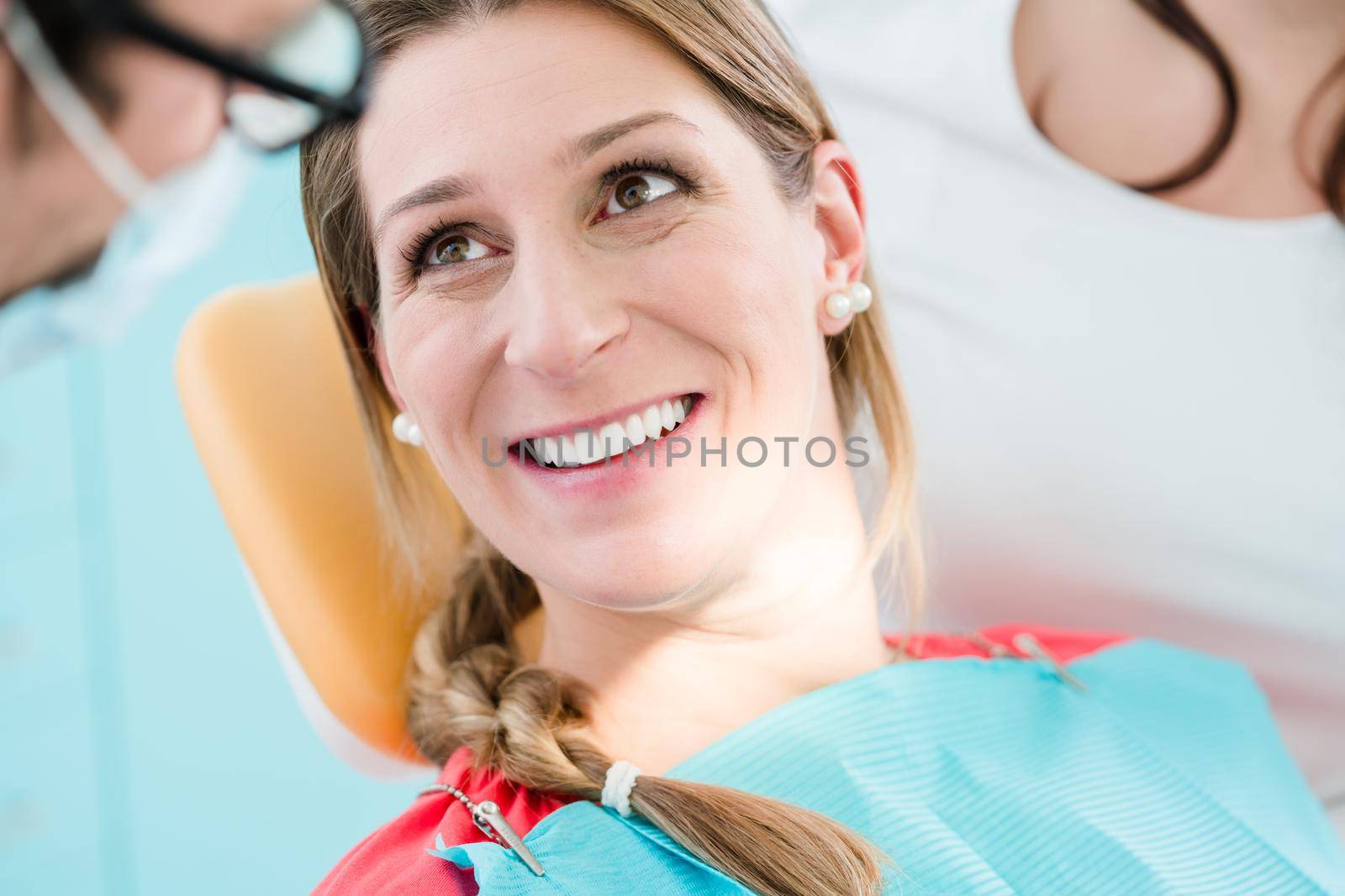 Woman with healthy smile at dentist after successful treatment