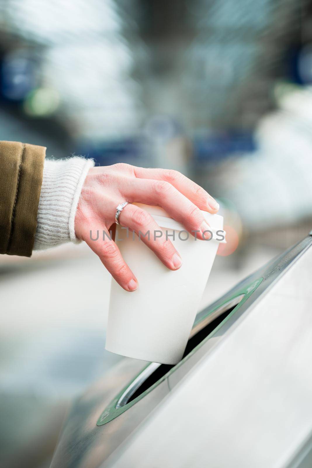 Woman using waste separation container throwing away coffee cup made of Styrofoam