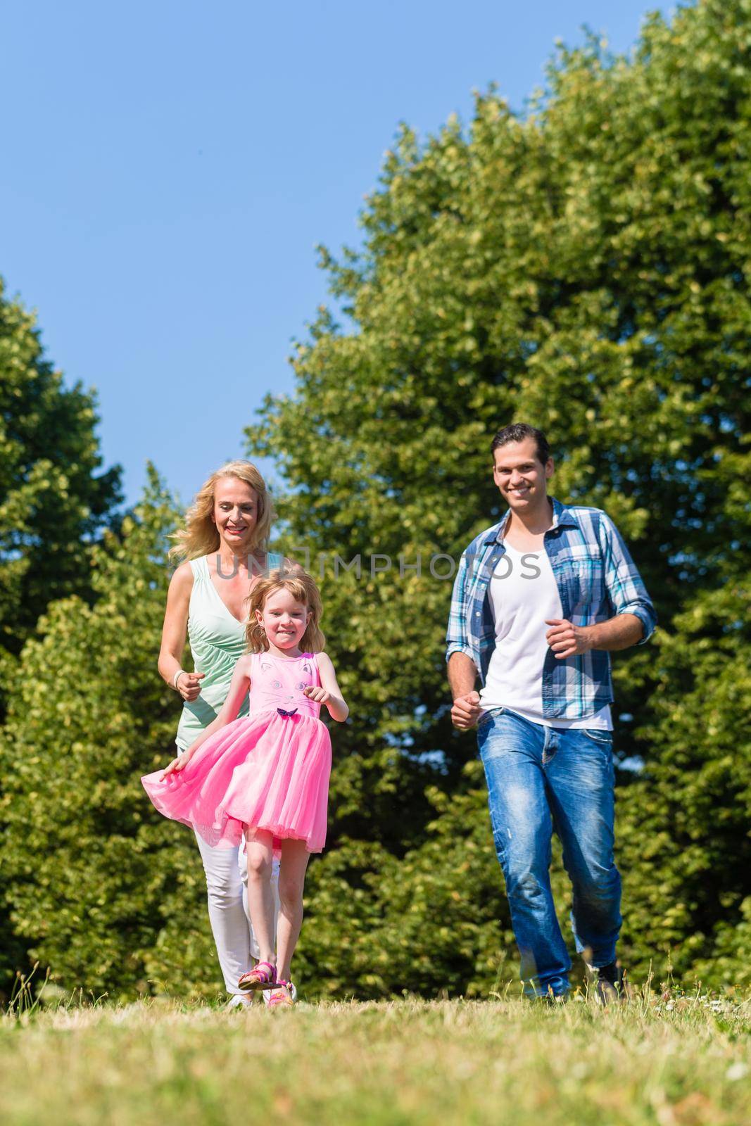 family playing catch or tag in summer outdoors