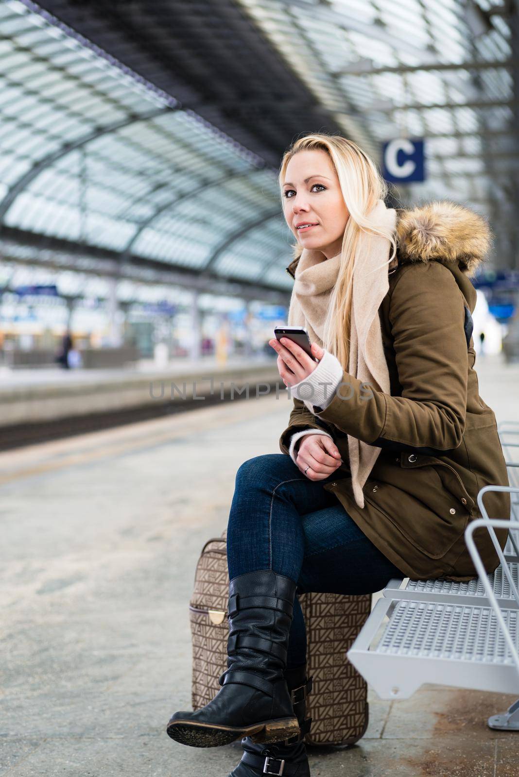 Woman on train station platform waiting on bench