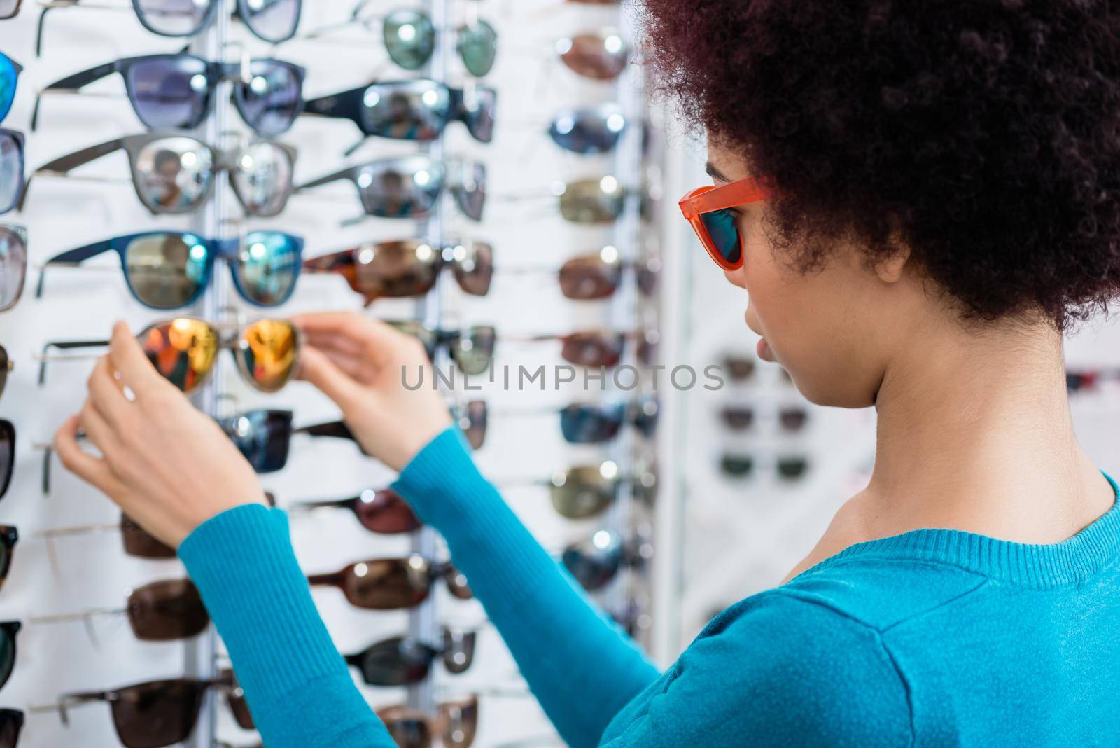 Black woman wearing sunglasses in optician shop by Kzenon