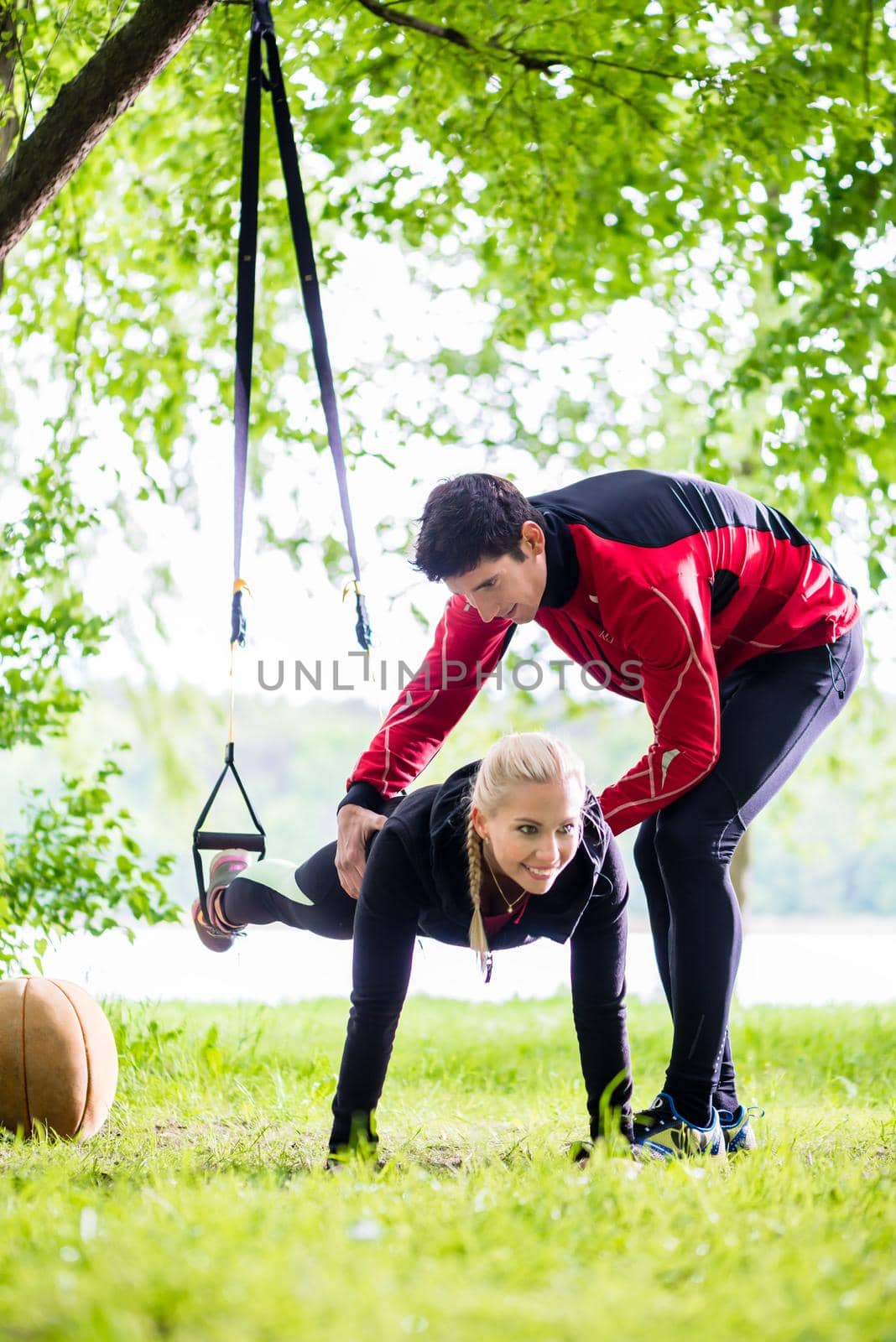 Man and woman at fitness training doing push-ups by Kzenon