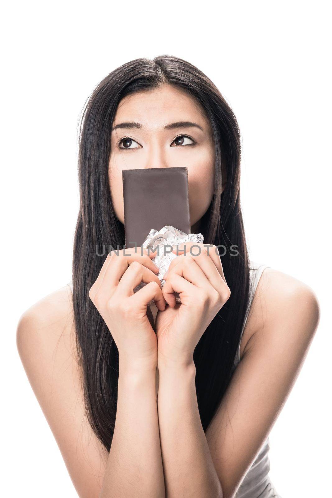 Portrait of young Asian woman looking up while holding a chocolate bar
