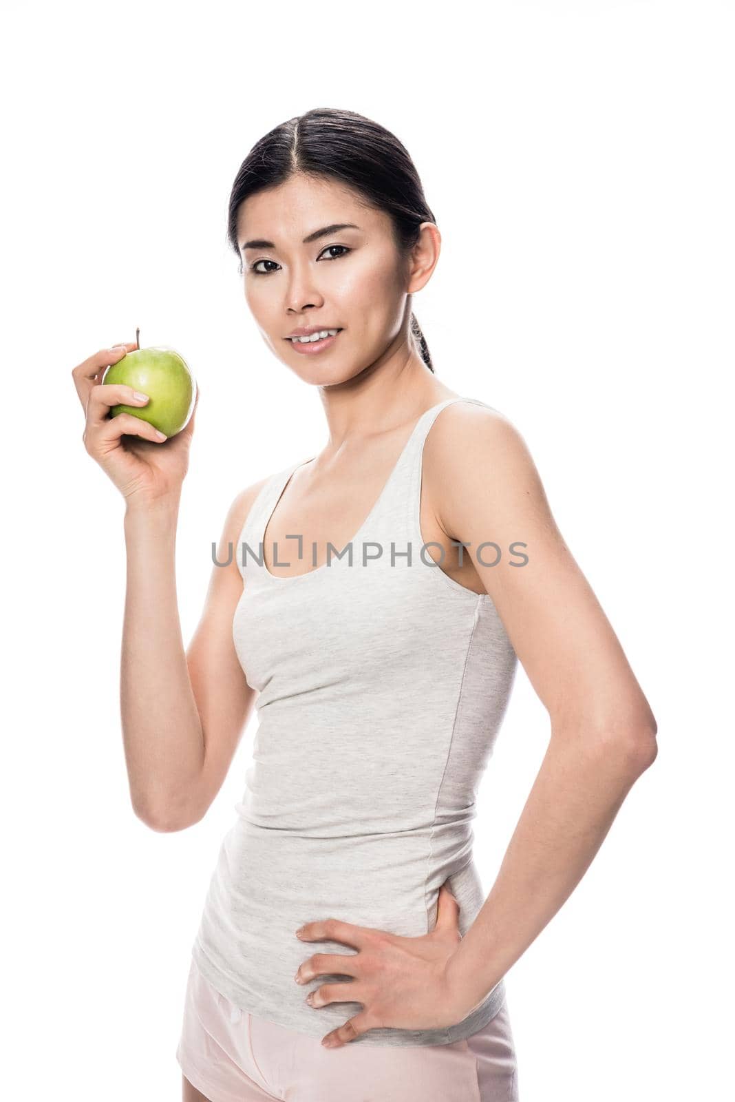 Happy Asian young woman holding a green apple by Kzenon