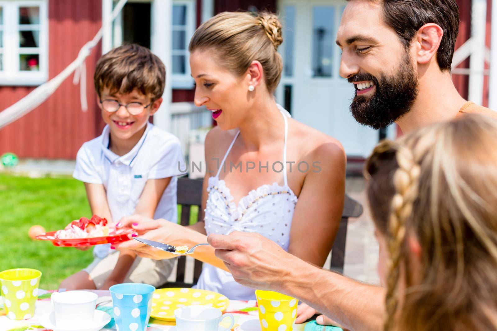 Family with cake in summer garden