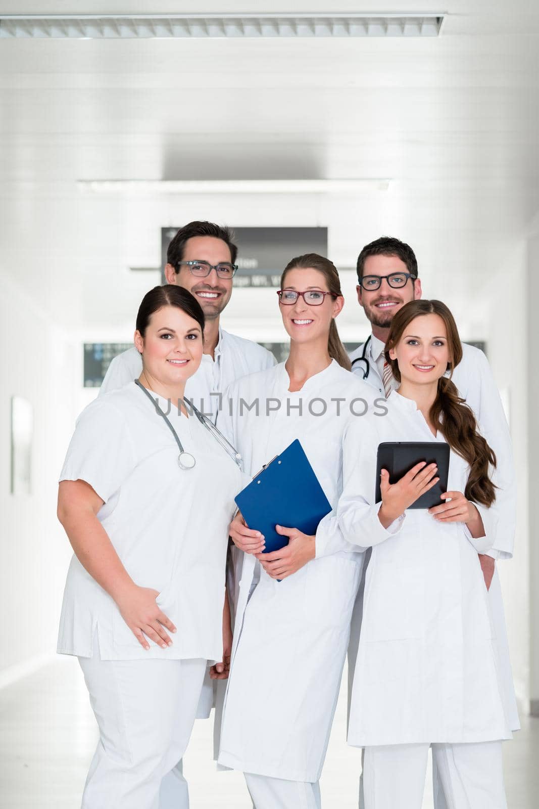 Team of doctors standing in hospital corridor by Kzenon