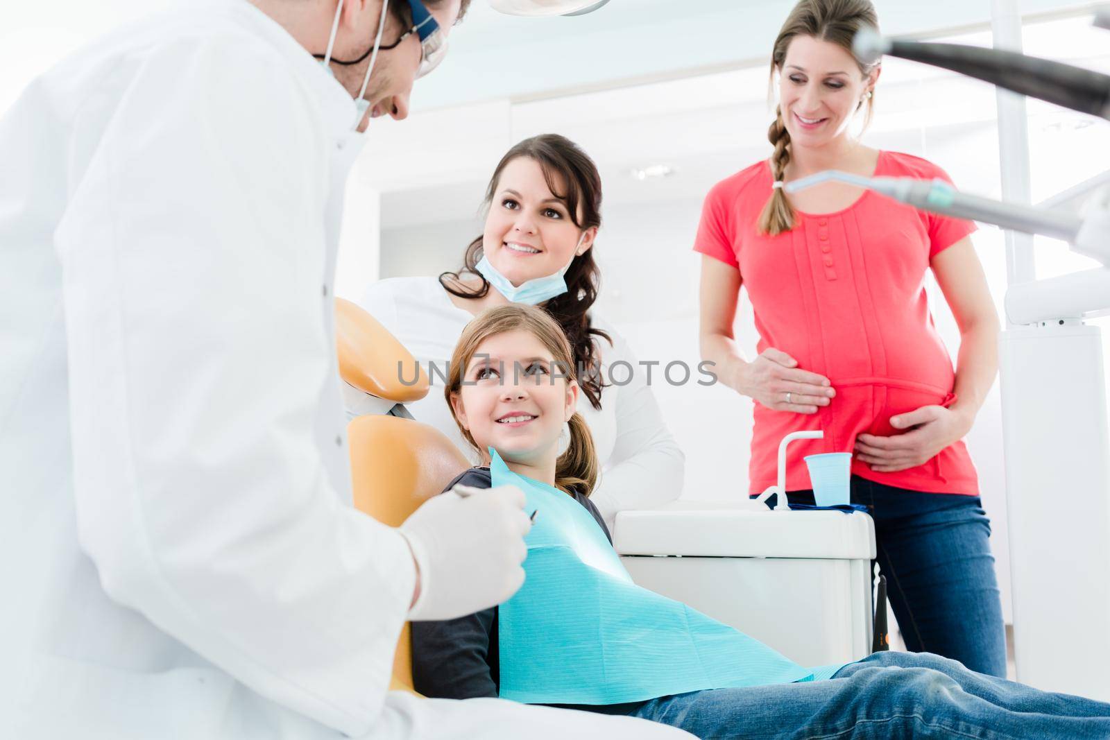 Dentist treating the whole family in his office by Kzenon