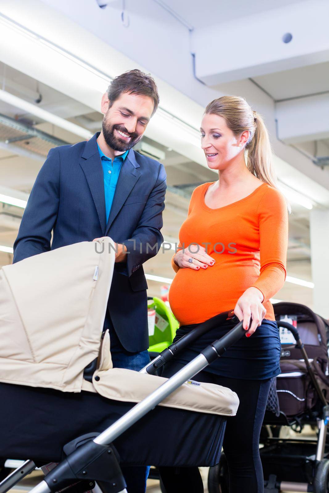 Couple in baby shop buying stroller by Kzenon