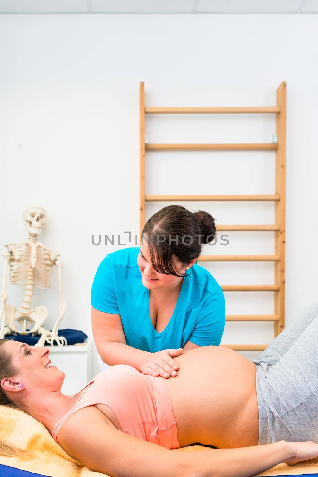 Pregnant woman at physical therapy on couch by Kzenon