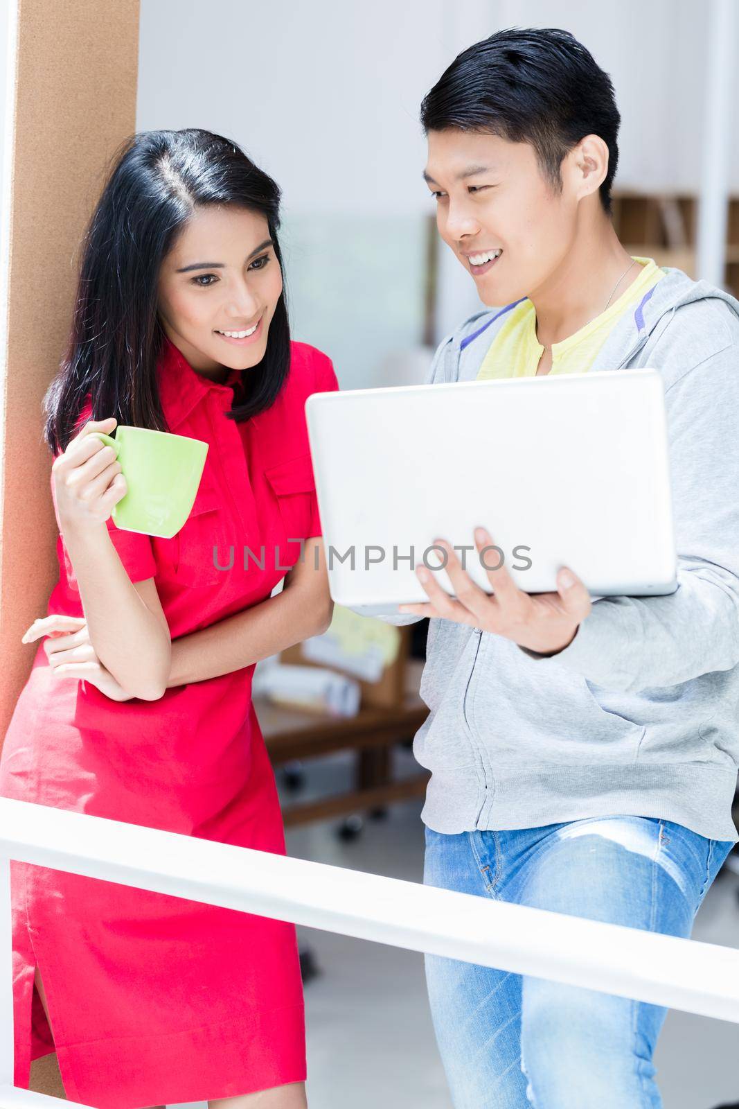 Two determined employees smiling while planning a successful business strategy for the future of the company