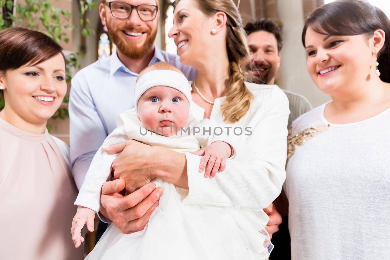 Parents and godparents gather with the baby after the christening ceremony