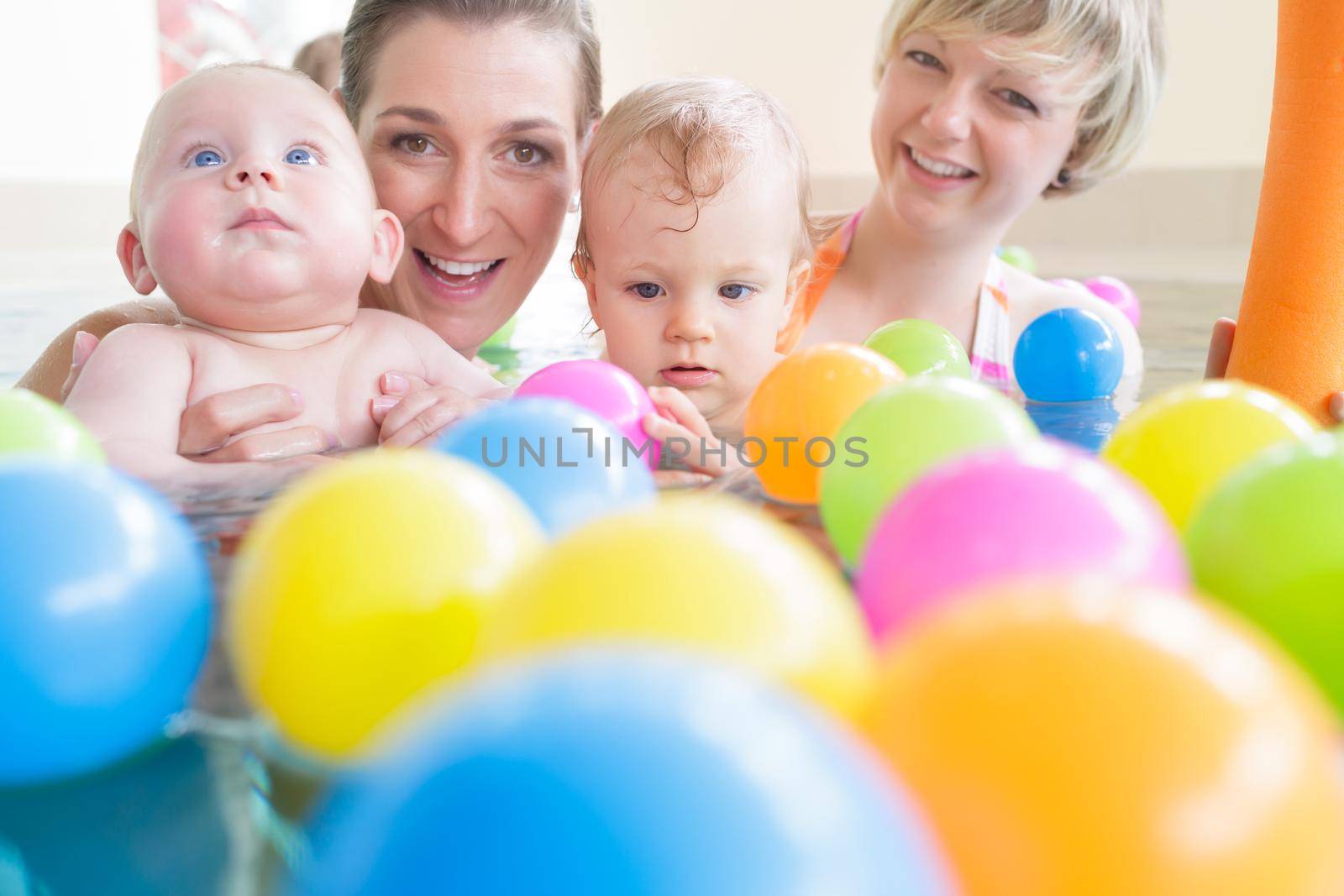 Mums and babies having fun at infant swimming course by Kzenon