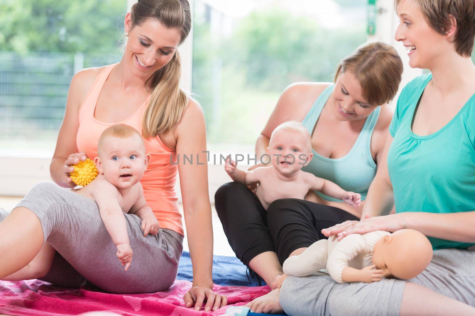 Young women practicing massage for their babies by Kzenon