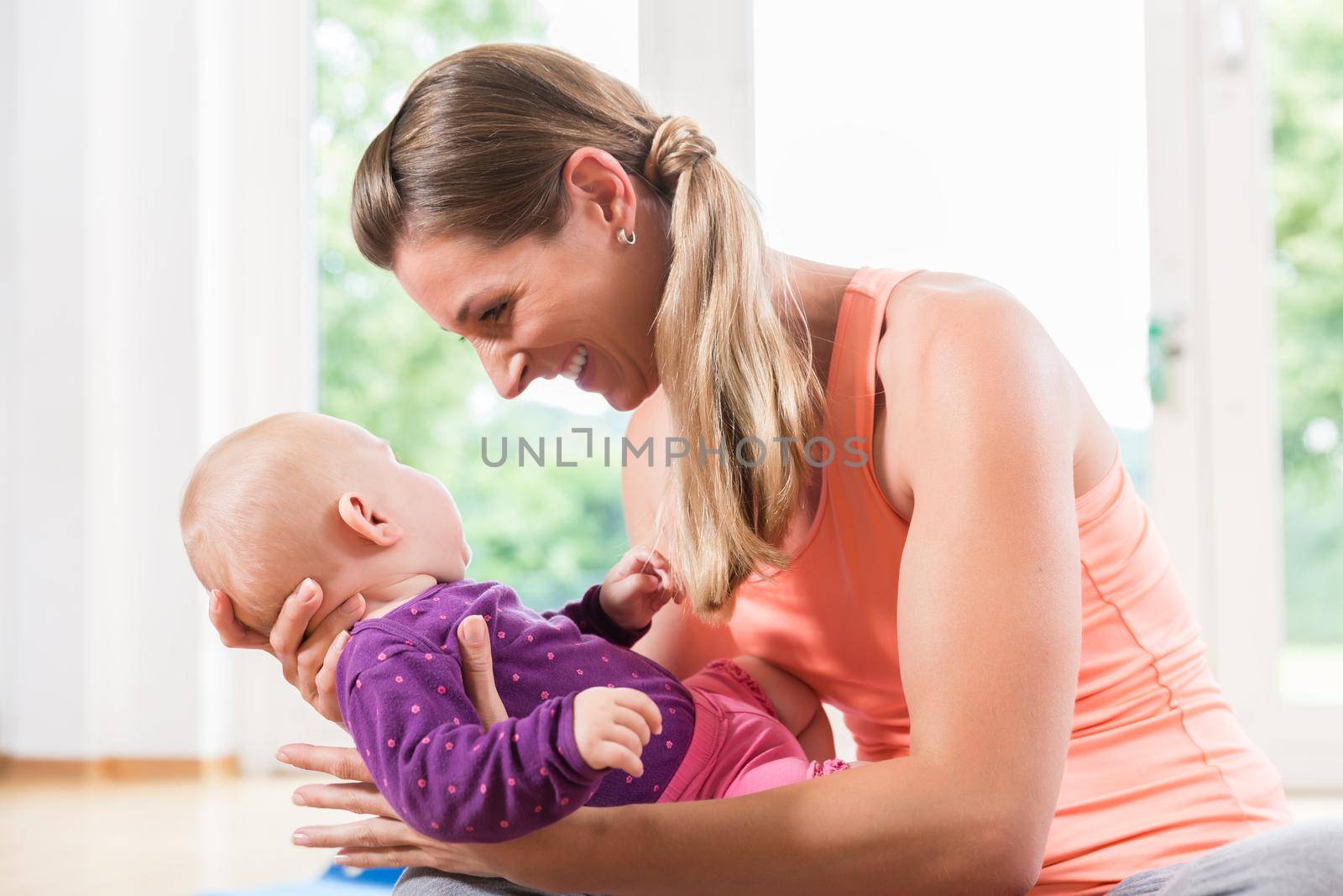 Mom and newborn baby playing together in baby course by Kzenon