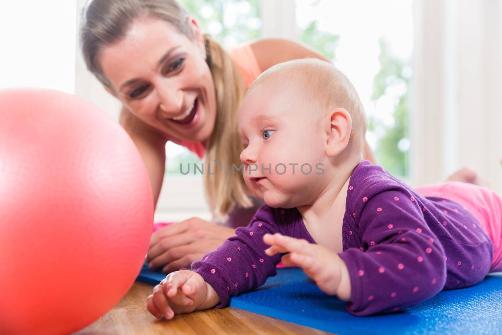 Mom and her baby practicing to crawl in mother and child course learning together