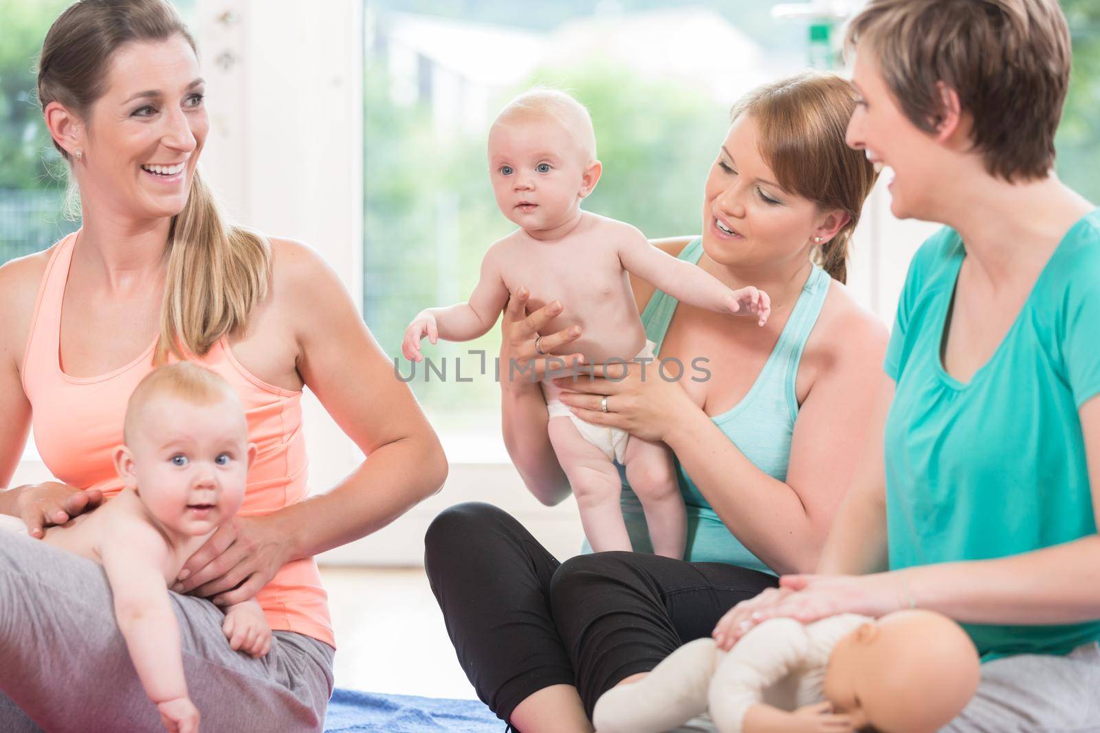 Moms and their babies practicing diaper change in mother and child class
