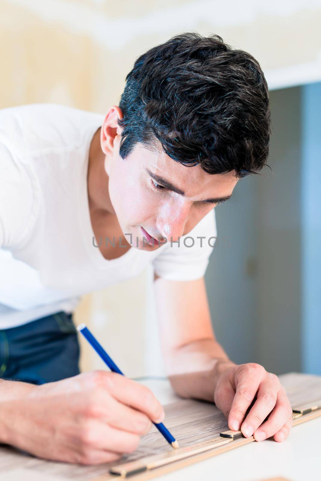 Carpenter measuring wood piece for flooring