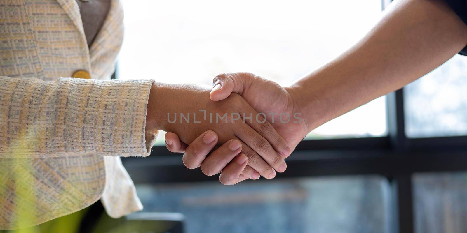 Close up of Business people shaking hands, finishing up meeting, business etiquette, congratulation, merger and acquisition concept by wichayada