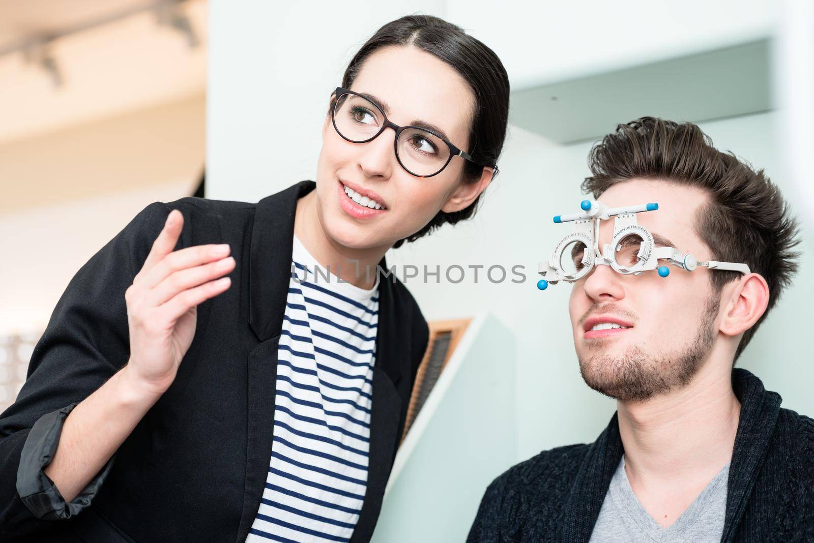 Man with optician at eyesight test for glasses by Kzenon