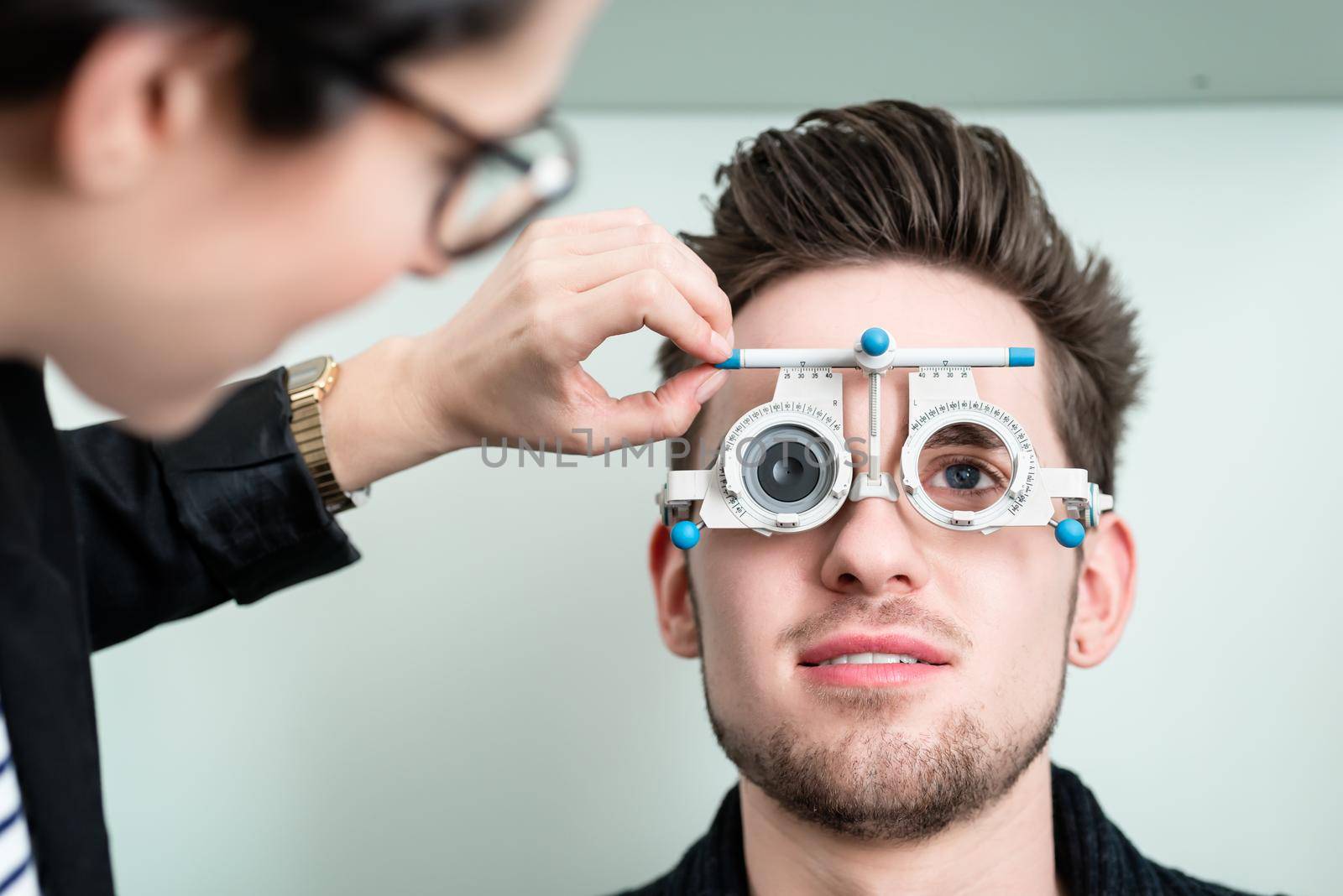 Man with optician at eyesight test for glasses by Kzenon