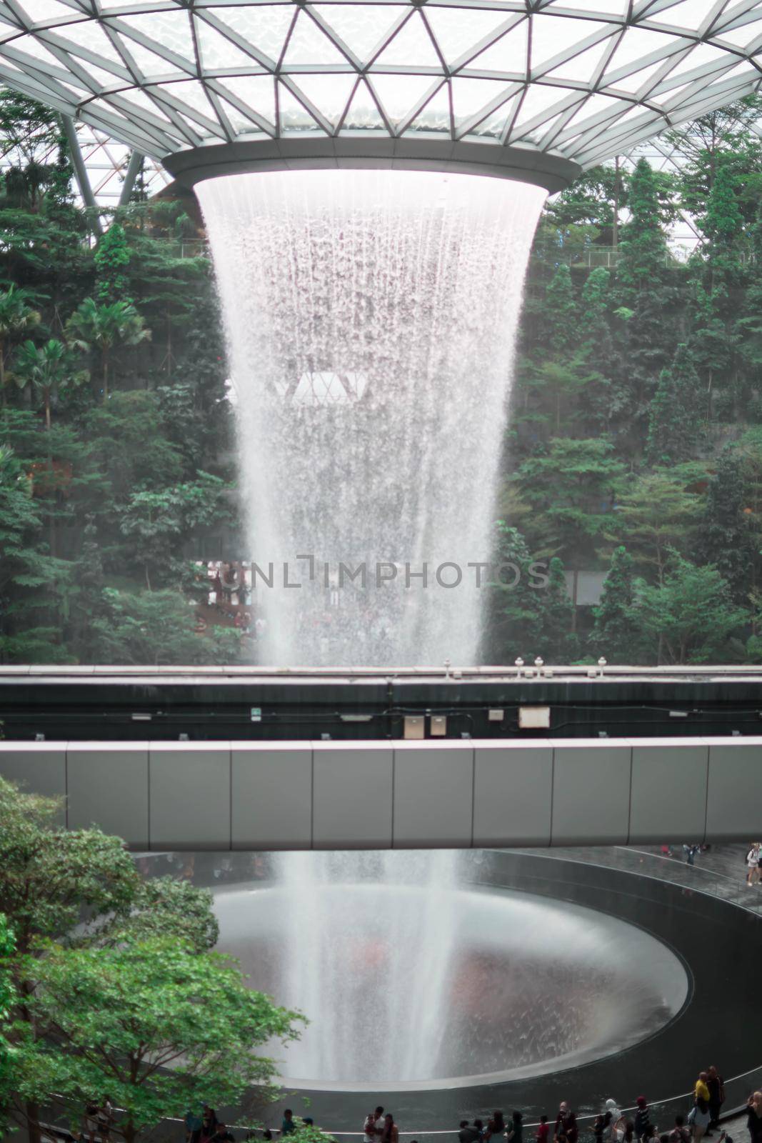 SINGAPORE - 21 DEC 2019: Rain Vortex the largest indoor waterfall located in Jewel Changi Airport with MRT and Tourists.