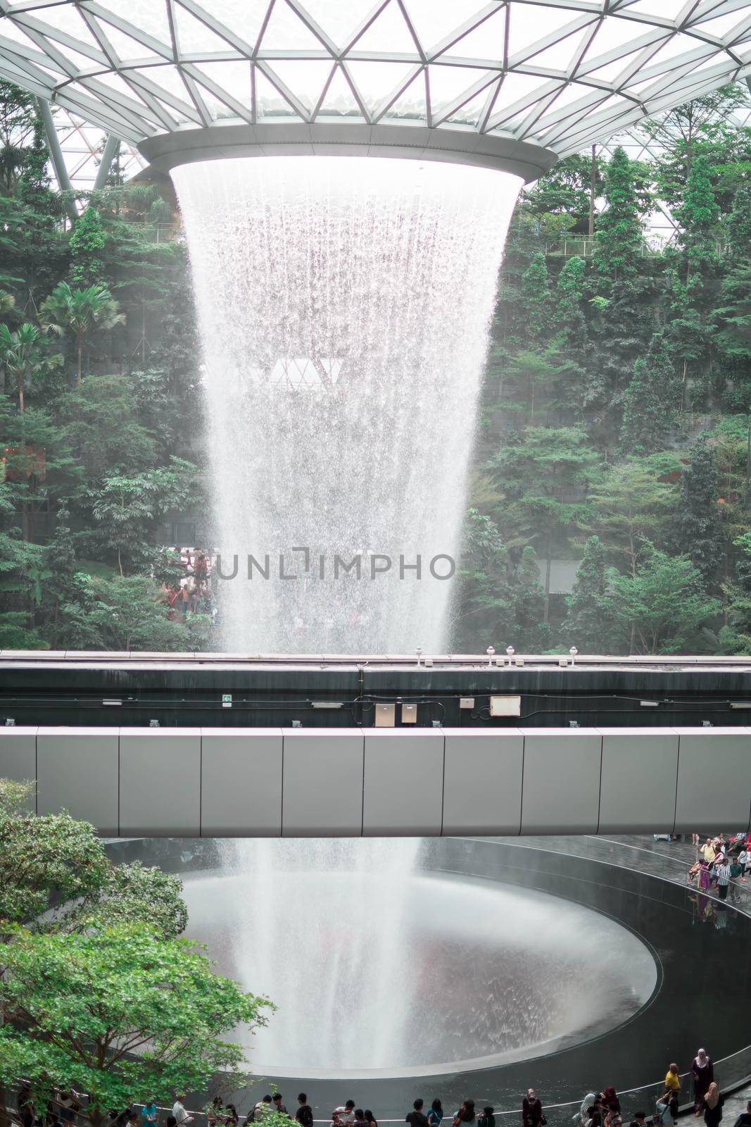 SINGAPORE - 21 DEC 2019: Rain Vortex the largest indoor waterfall located in Jewel Changi Airport with MRT and Tourists.