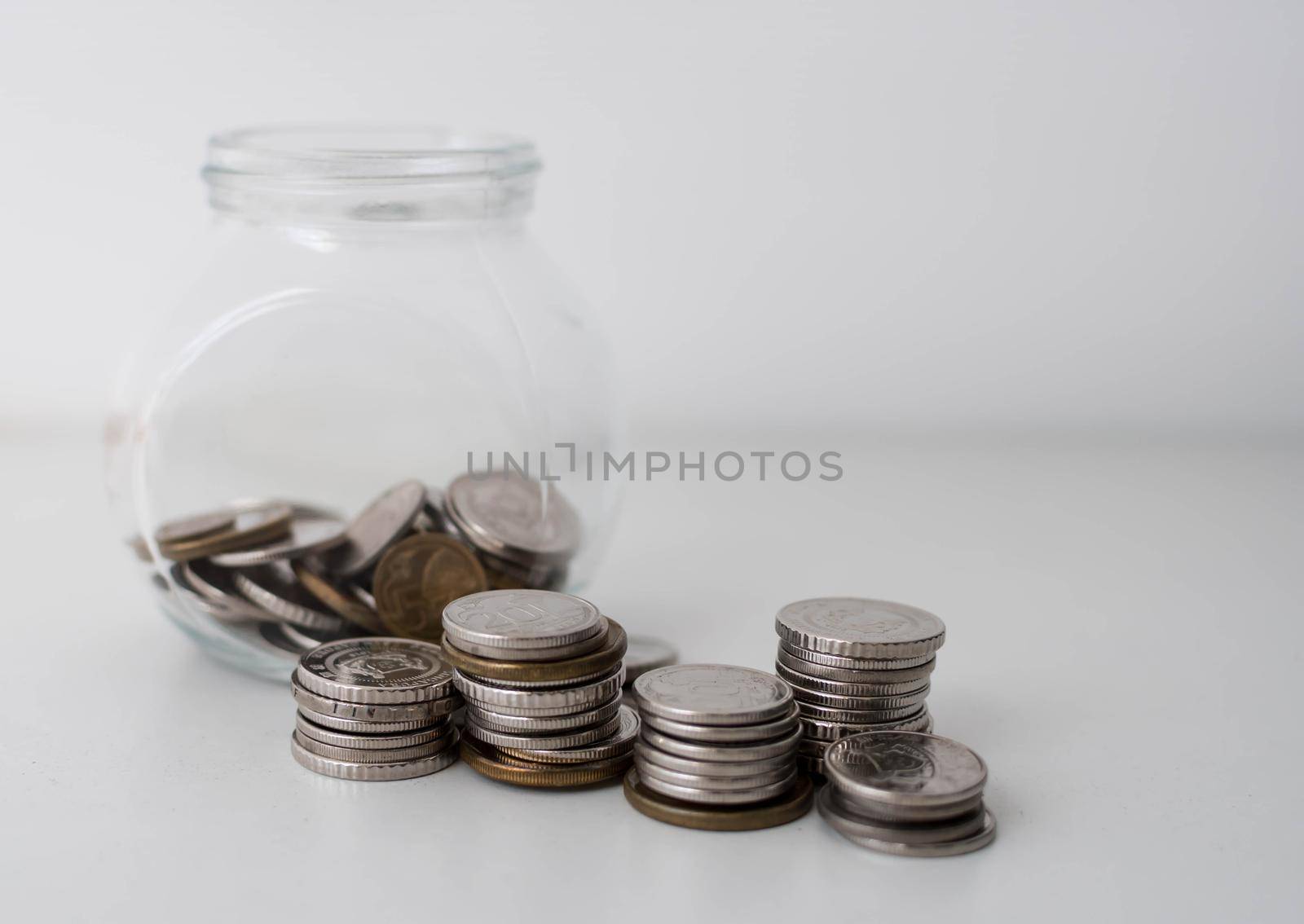 Pile of coin in glass bottle on white background. Savings and investment plan concept. Jar, coins, savings, investment, donation. Coins in a jar