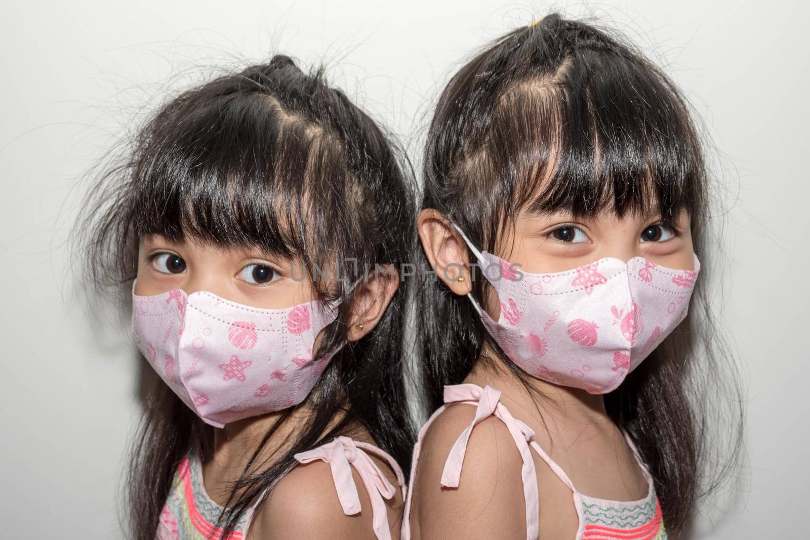 Asian female twins wearing a mask to protect against the Corona virus that can spread through the air