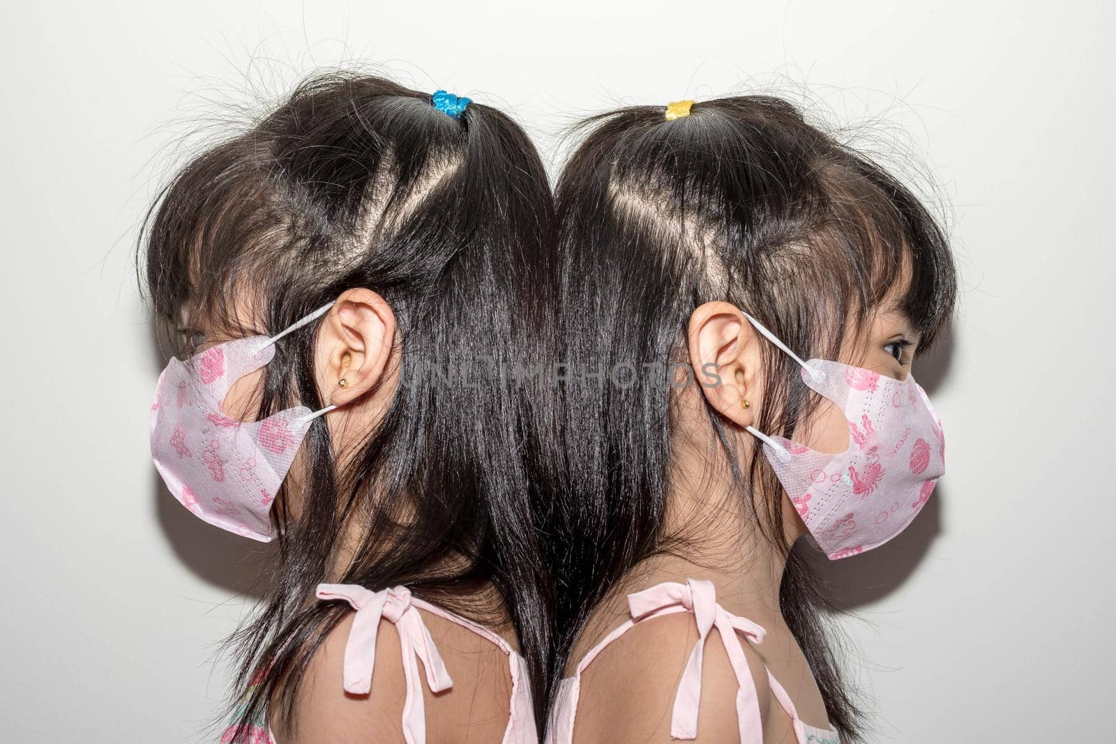 Asian female twins wearing a mask to protect against the Corona virus that can spread through the air