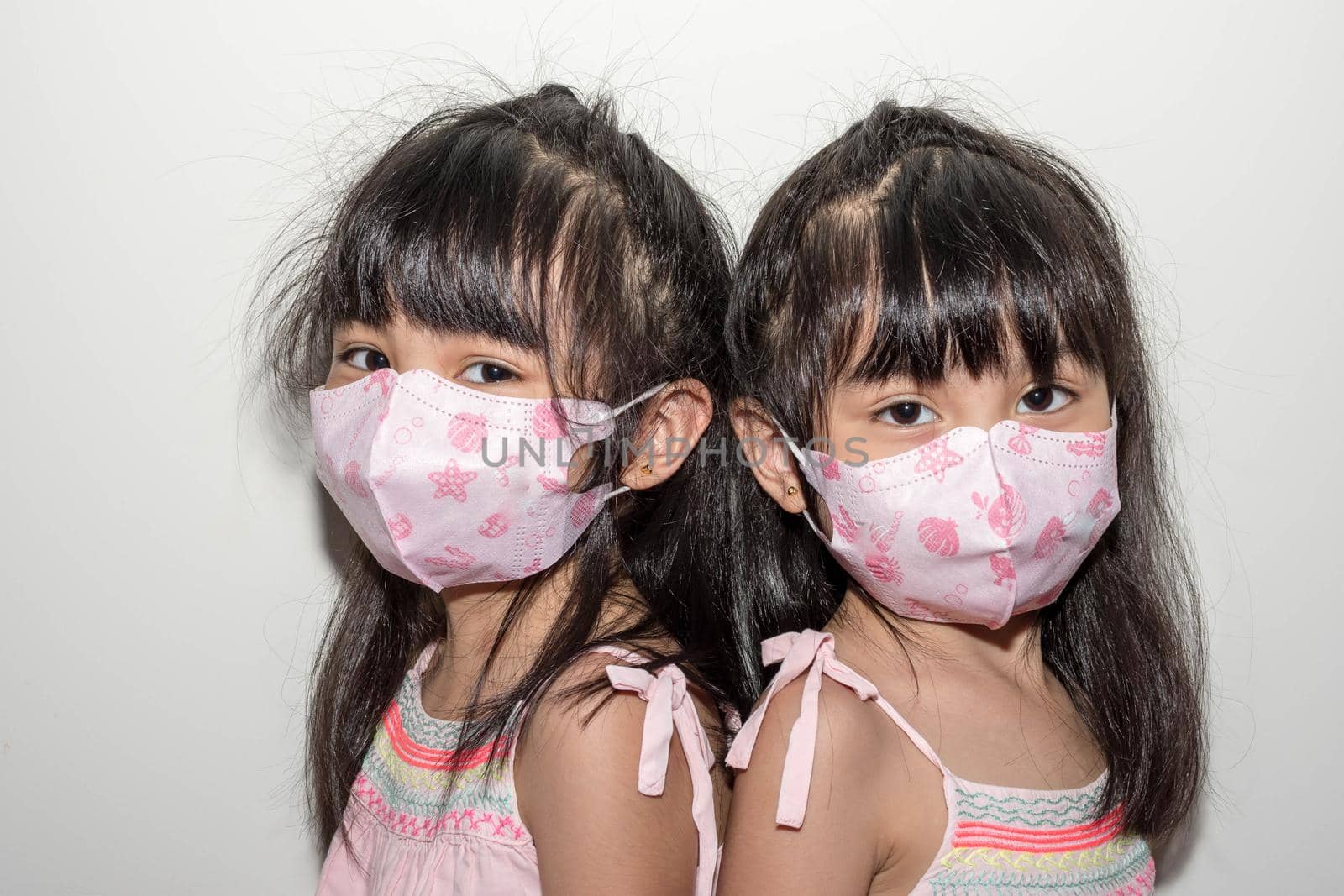 Asian female twins wearing a mask to protect against the Corona virus that can spread through the air