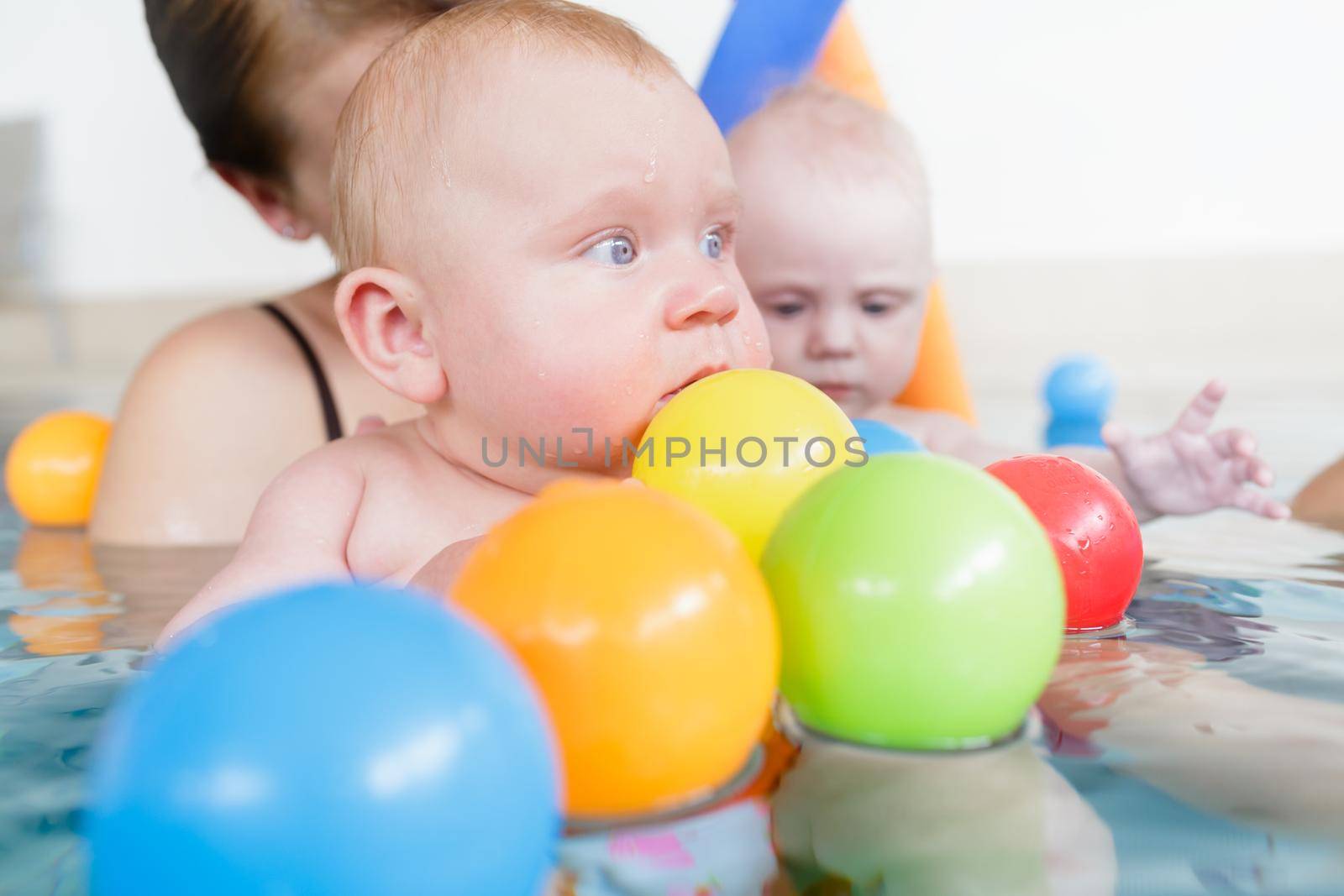 Mums and babies having fun at infant swimming course by Kzenon