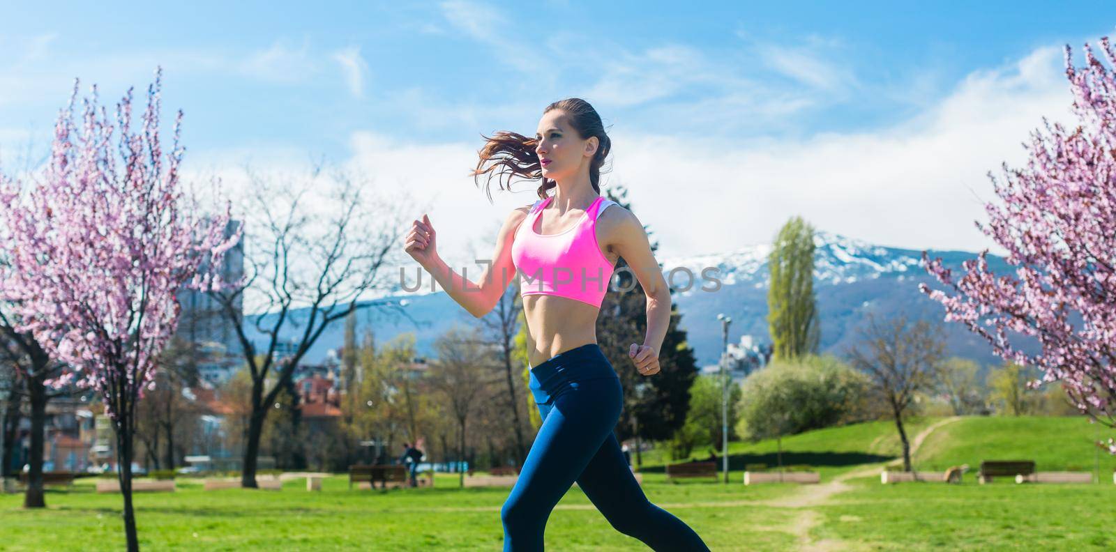 Woman running fast for sport on sunny day by Kzenon