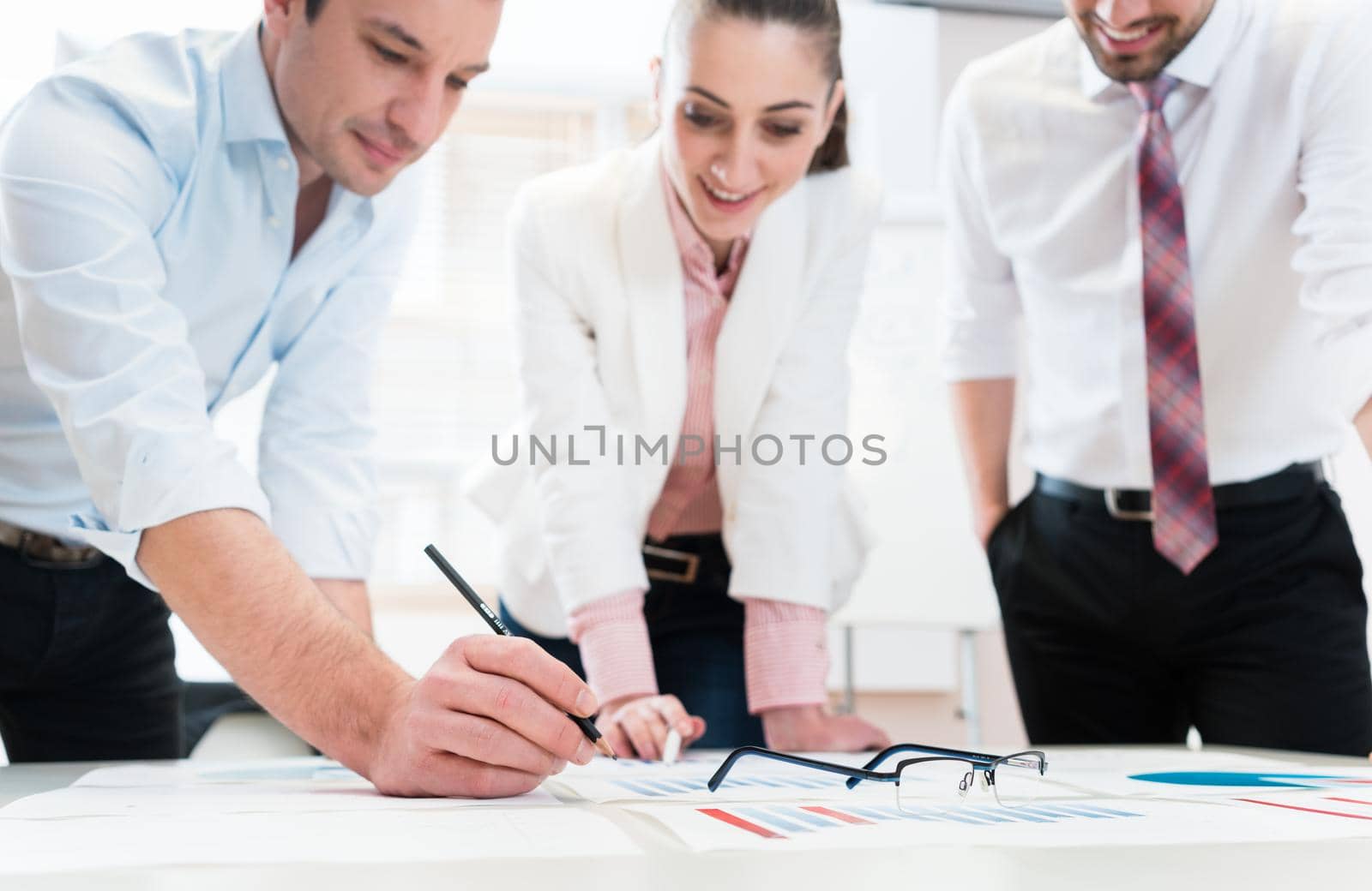 Business people analyzing financial data - glasses on graph, symbol for focus and detail