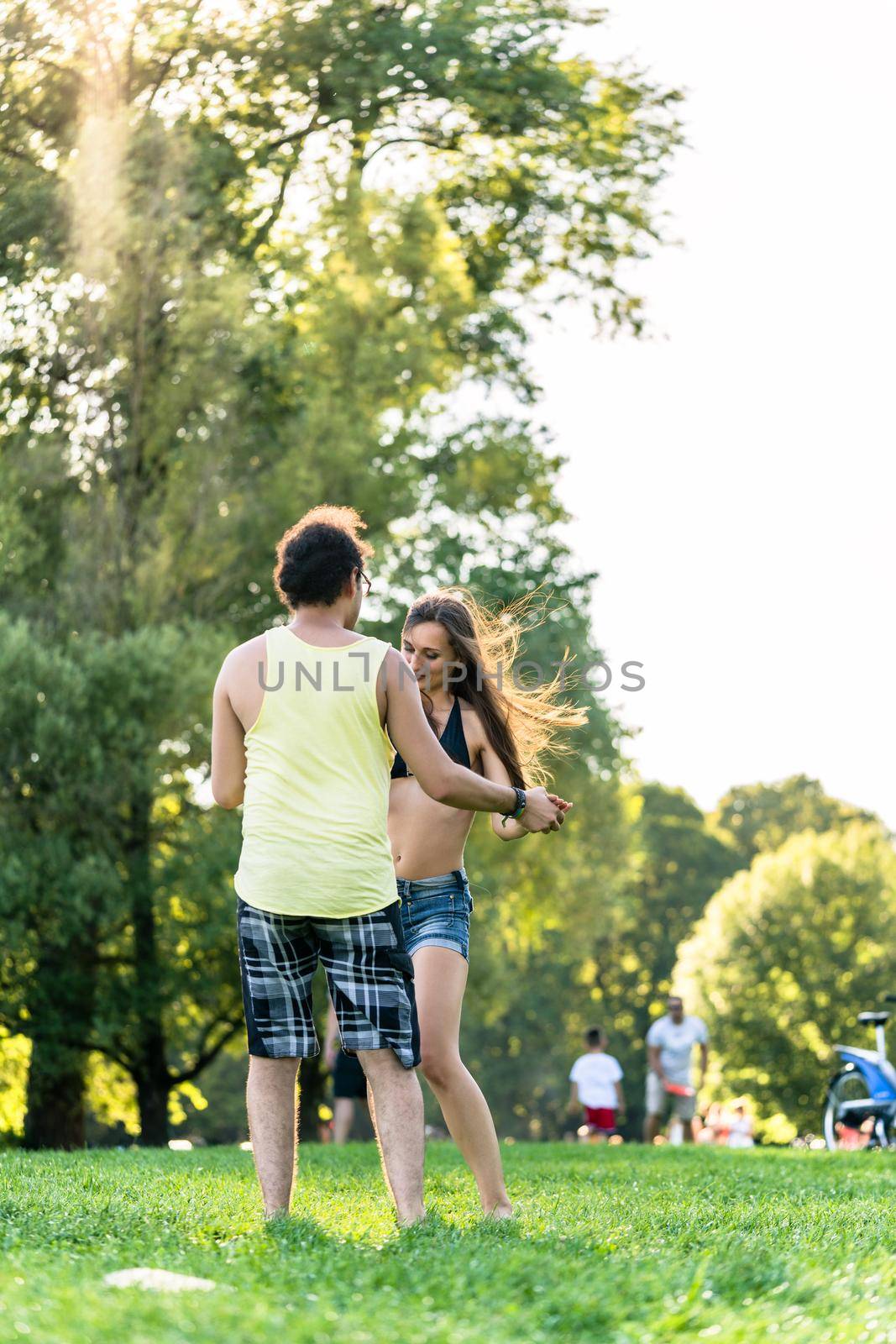 Woman and man dancing in park outdoors by Kzenon