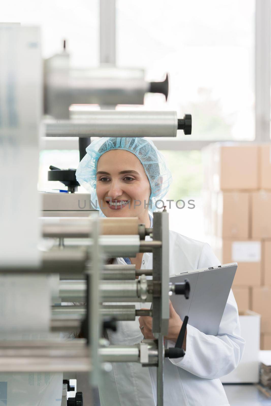 Female manufacturing supervisor looking worried while checking equipment and production during quality control in the interior of a cosmetics factory