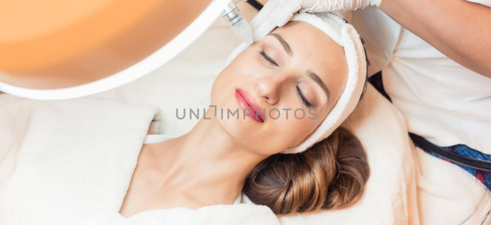 Close-up of the face of a woman relaxing in a modern beauty center during facial treatment with innovative technology for softening wrinkles and rejuvenation