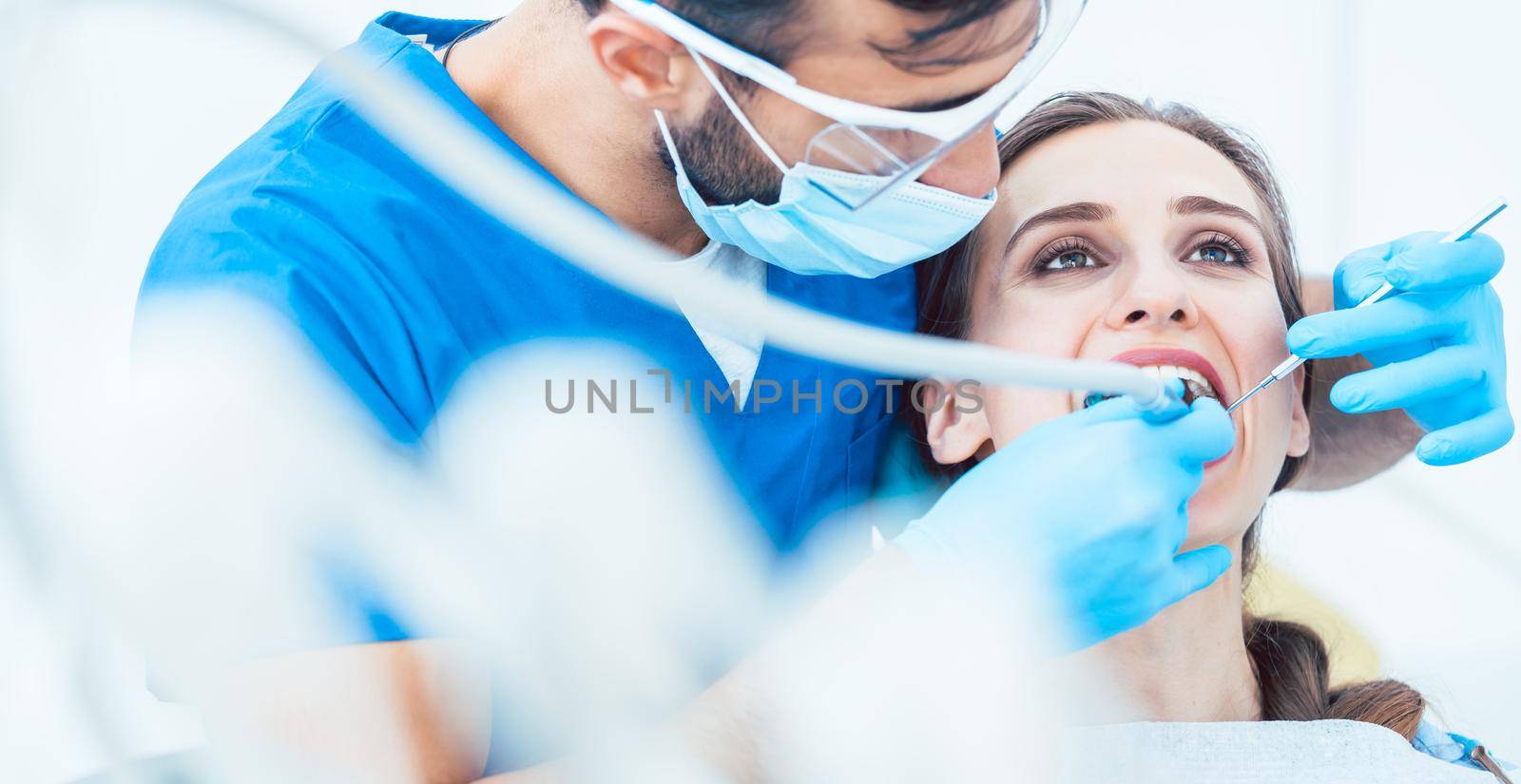 Beautiful young woman looking up relaxed during a painless dental procedure by Kzenon