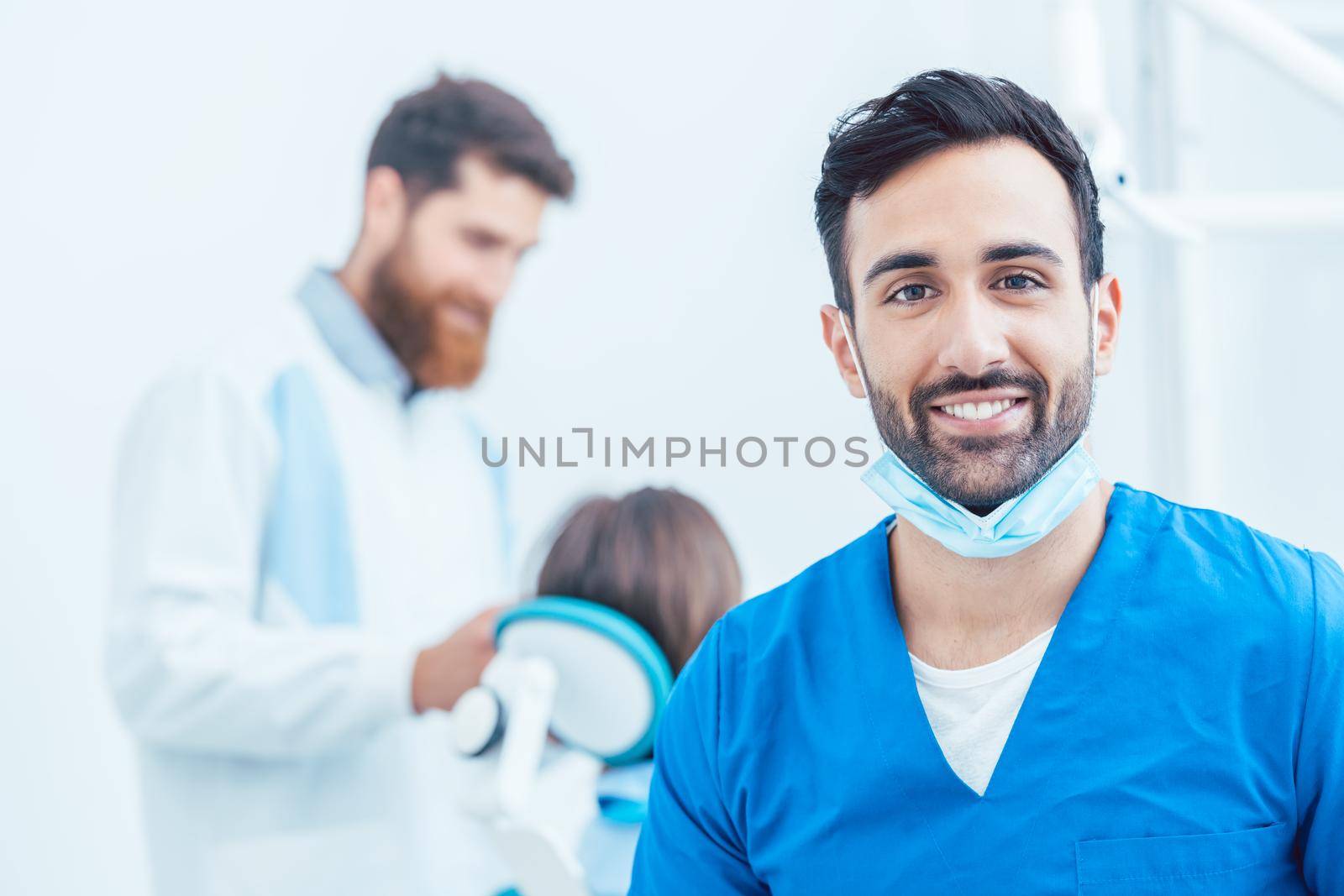 Portrait of a confident dental surgeon in a modern dental office by Kzenon