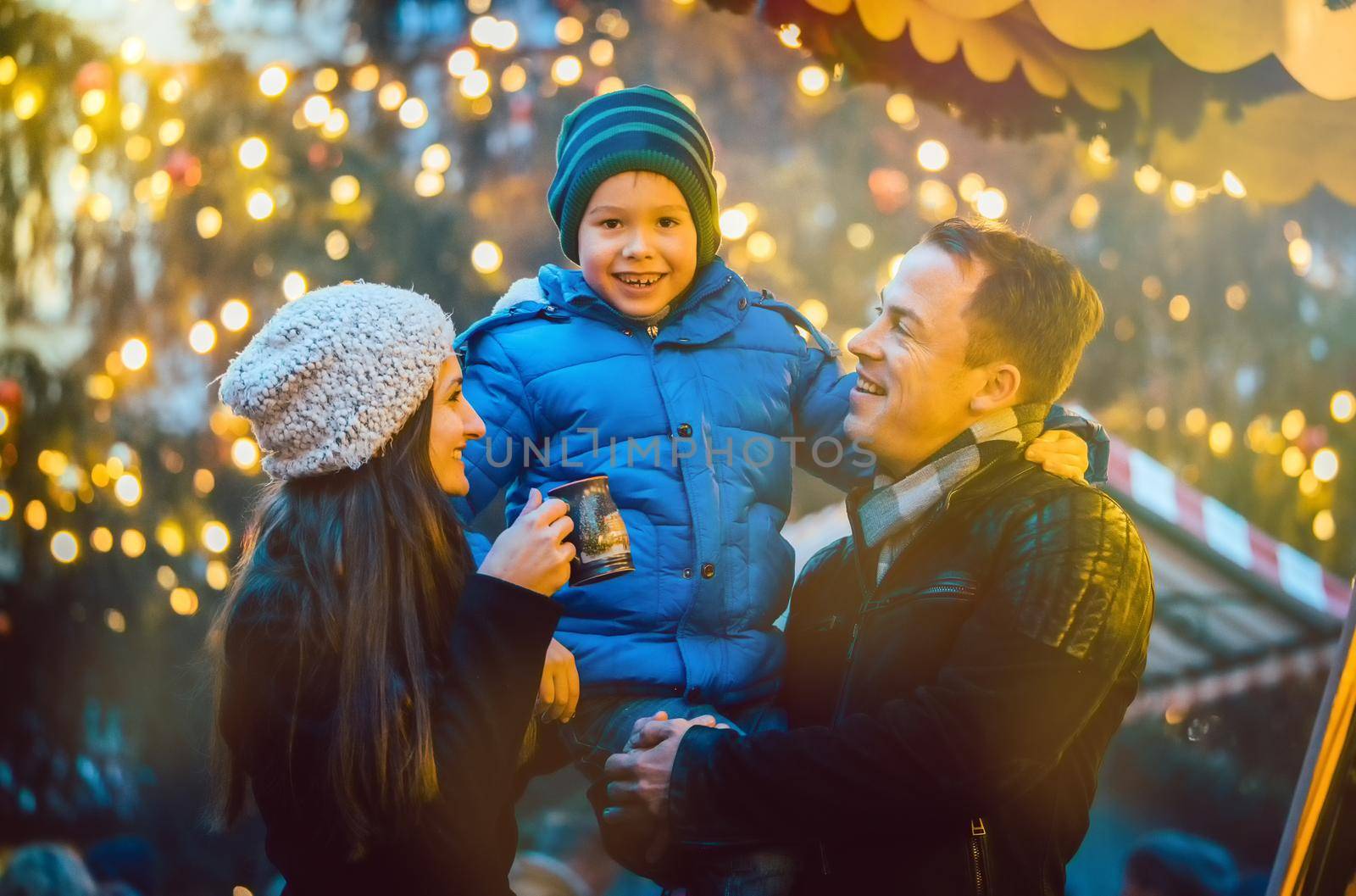 Family having fun on Christmas market, dad holding his son