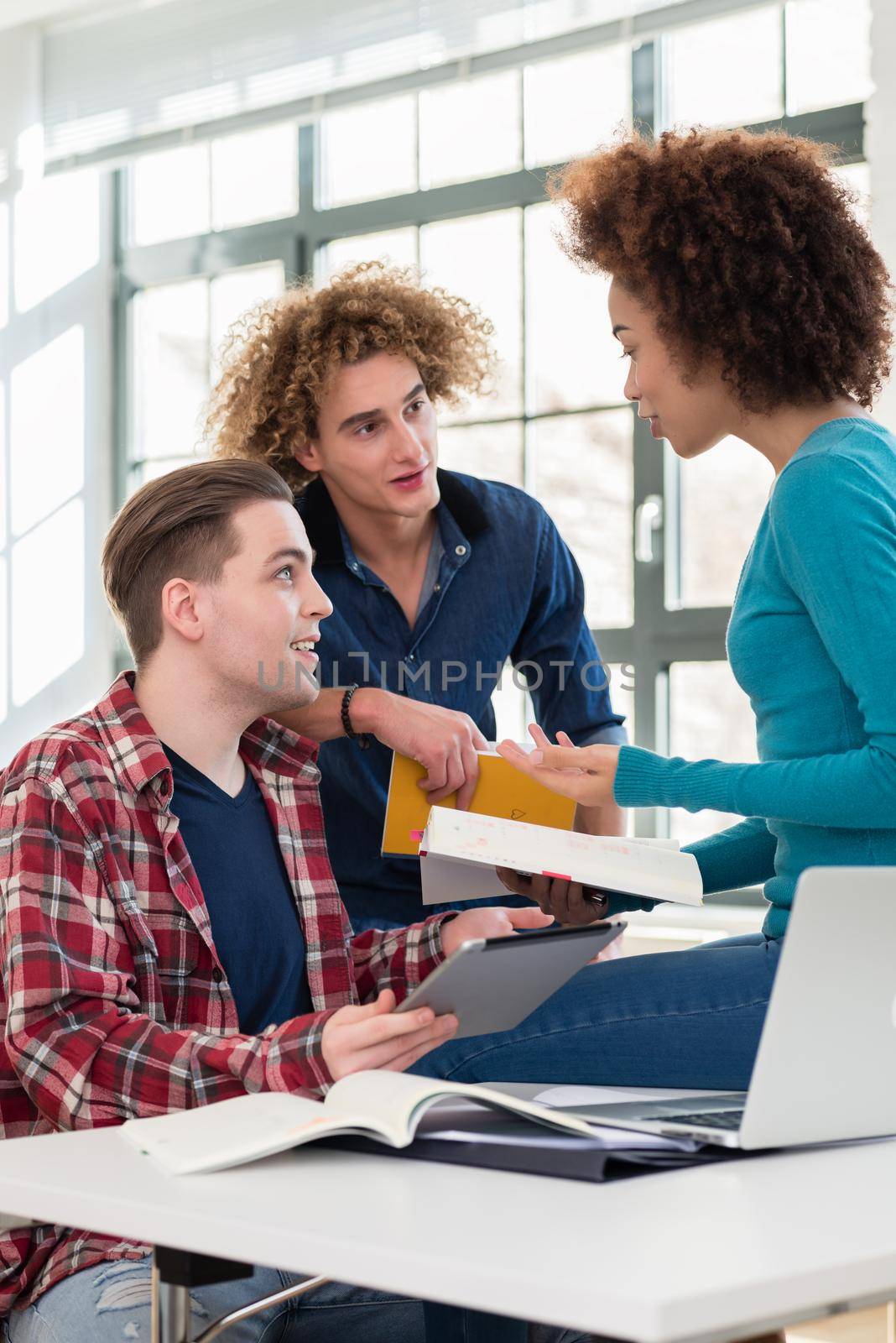 Three involved students sharing ideas and opinions about different topics and new information learned during courses at the university